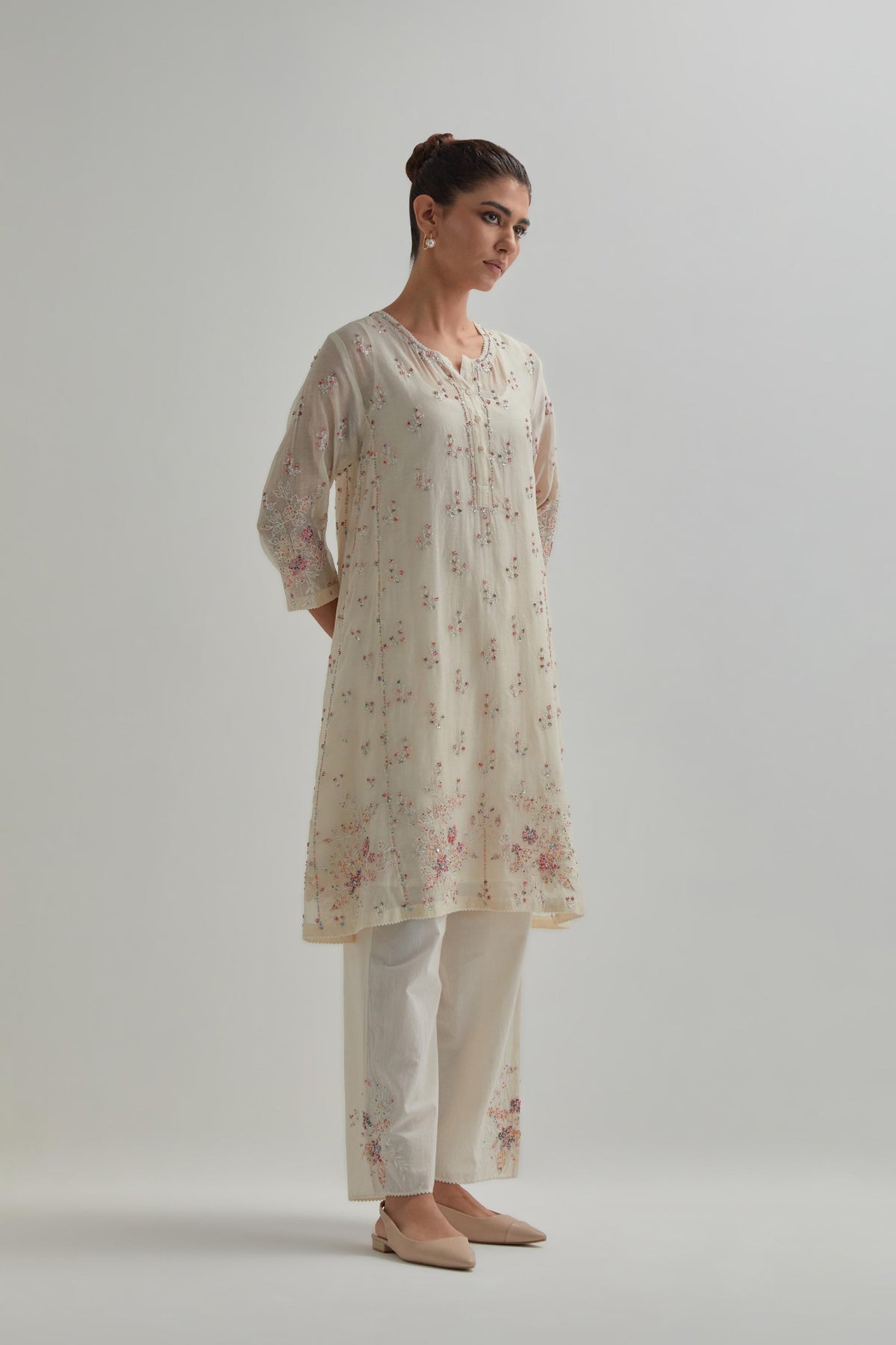 Off white cotton Chanderi short kalidar kurta set with all-over pink & beige hand block printed appliqué flowers, highlighted with sequins and multi coloured beads.