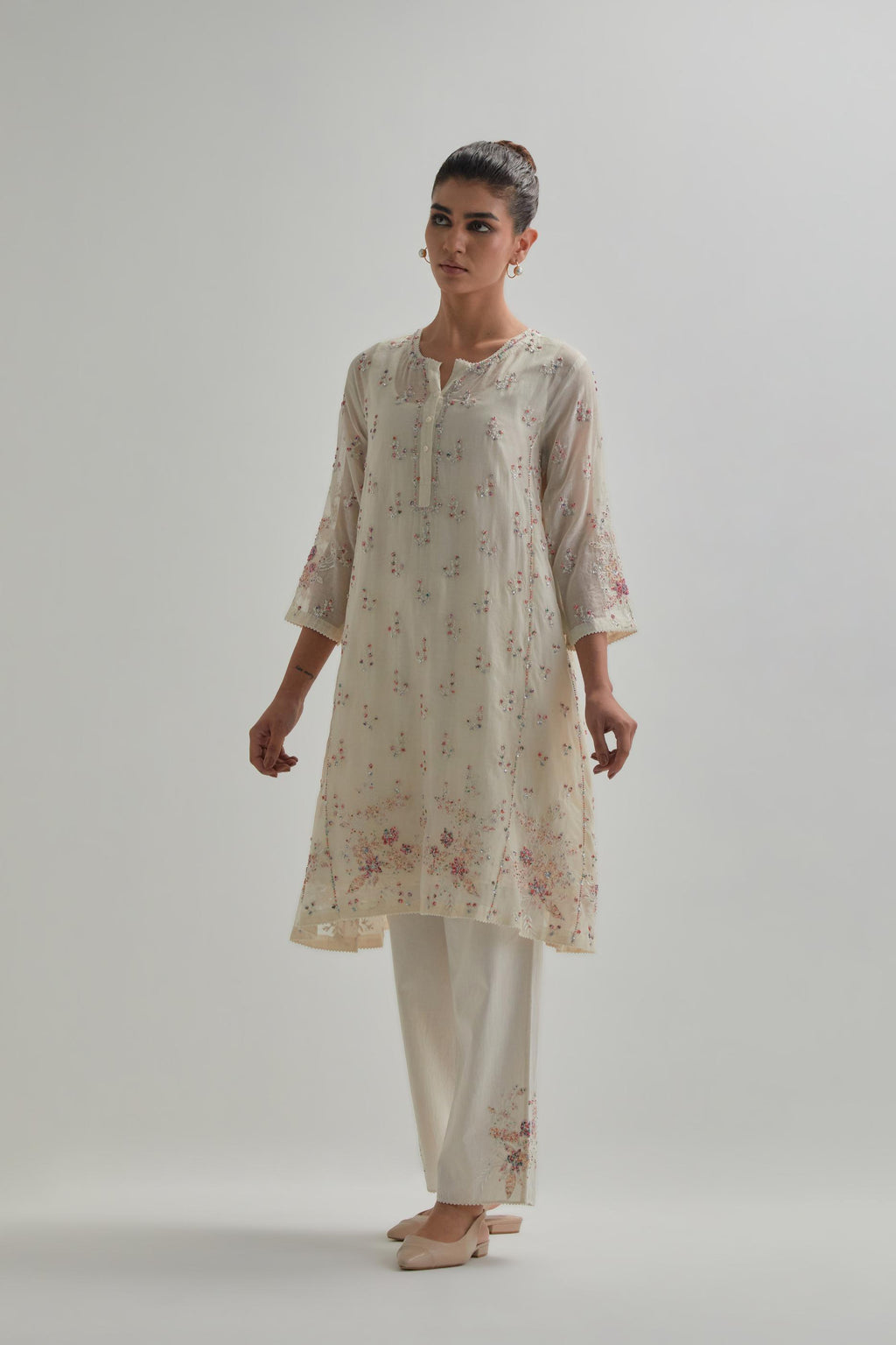 Off white cotton Chanderi short kalidar kurta set with all-over pink & beige hand block printed appliqué flowers, highlighted with sequins and multi coloured beads.