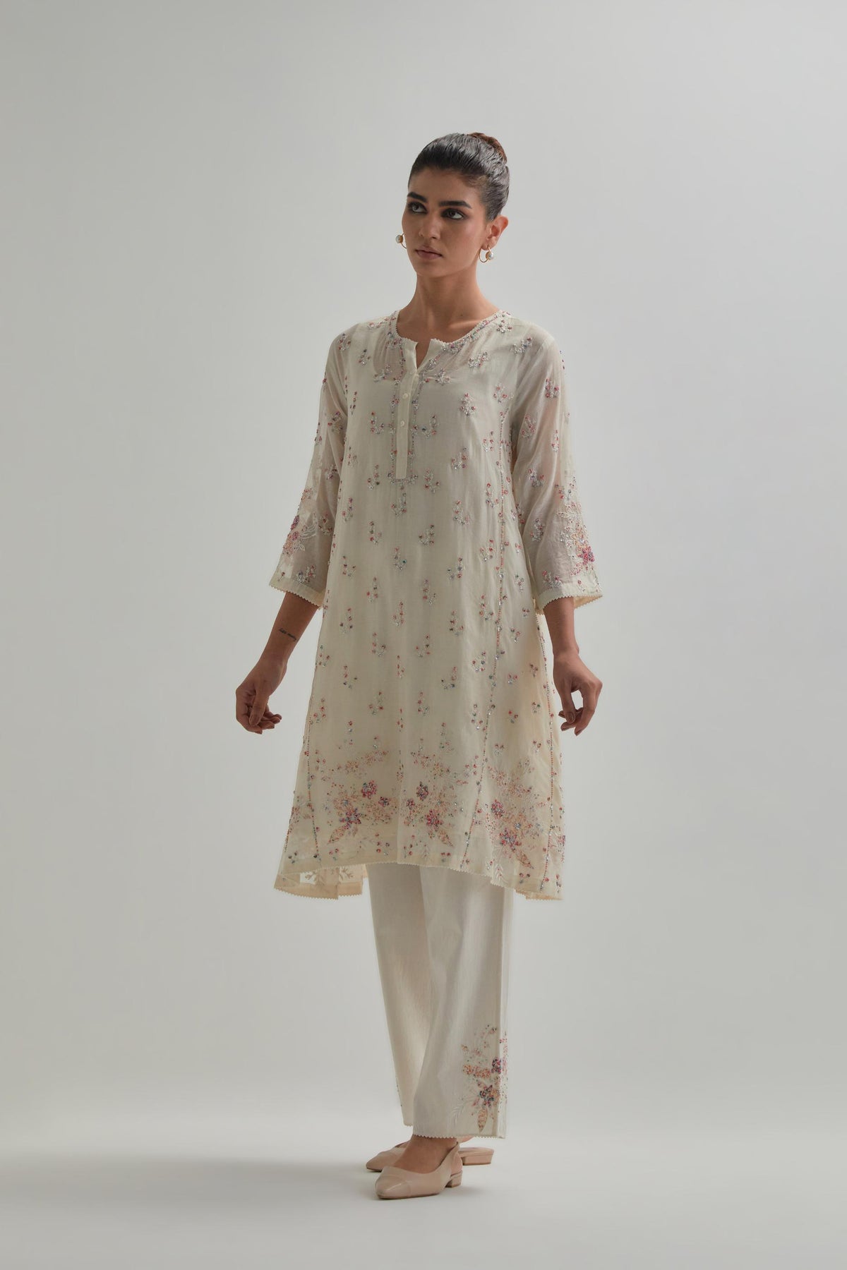 Off white cotton Chanderi short kalidar kurta set with all-over pink & beige hand block printed appliqué flowers, highlighted with sequins and multi coloured beads.