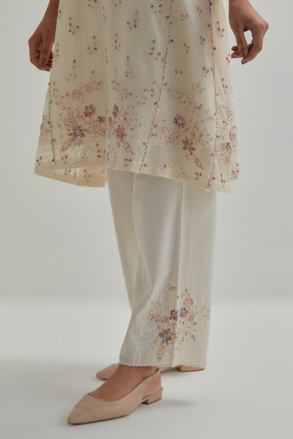 Off white cotton Chanderi short kalidar kurta set with all-over pink & beige hand block printed appliqué flowers, highlighted with sequins and multi coloured beads.