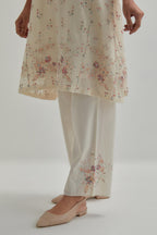 Off white cotton Chanderi short kalidar kurta set with all-over pink & beige hand block printed appliqué flowers, highlighted with sequins and multi coloured beads.