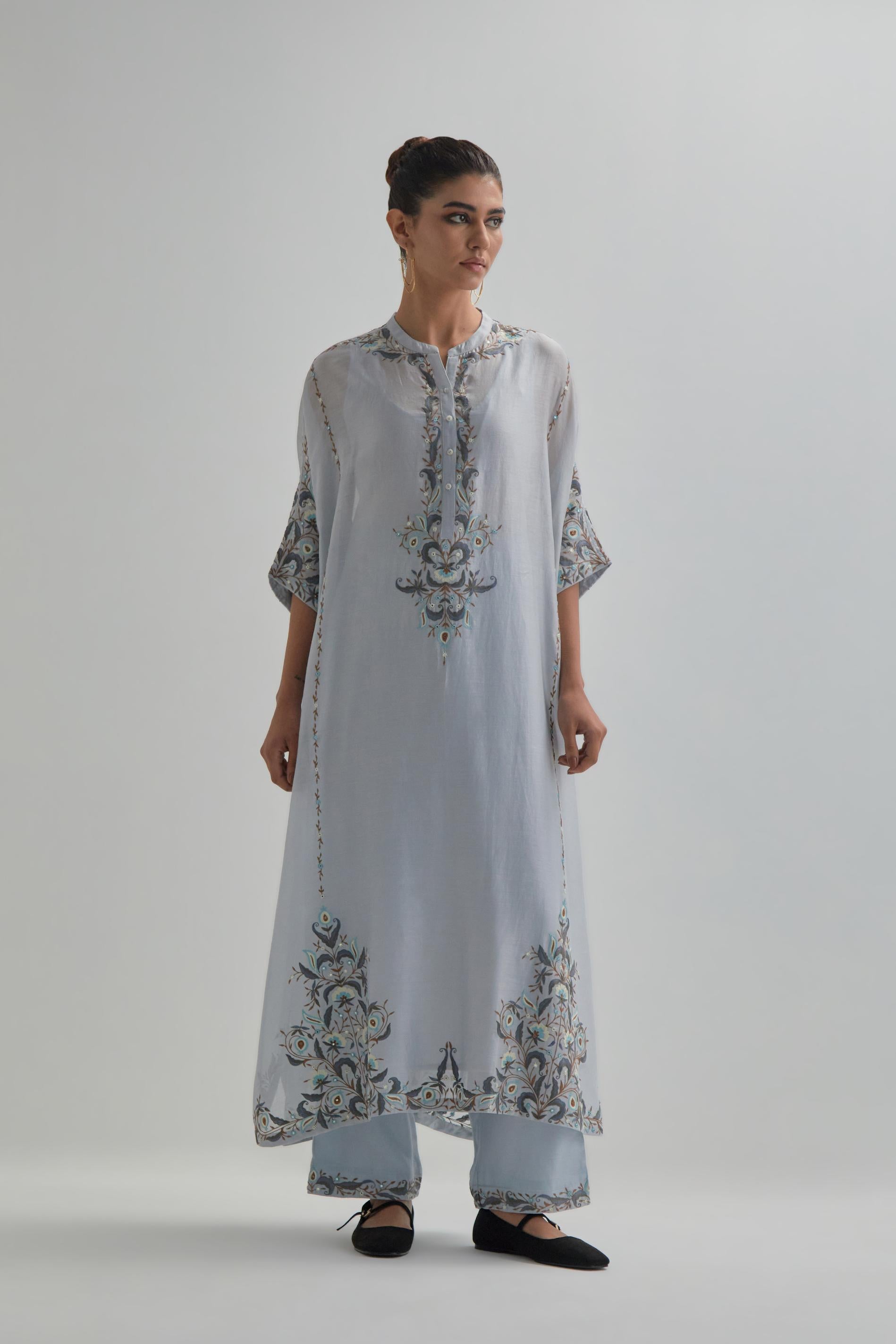 Blue Silk Chanderi easy fit kaftan with earthy coloured thread Aari embroidery, highlighted with silver sequins work, paired with Blue silk Chanderi straight pants with earthy coloured Aari work at hem.