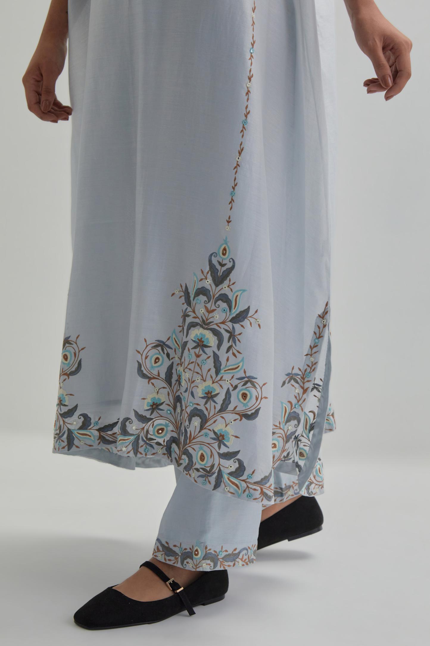 Blue Silk Chanderi easy fit kaftan with earthy coloured thread Aari embroidery, highlighted with silver sequins work, paired with Blue silk Chanderi straight pants with earthy coloured Aari work at hem.