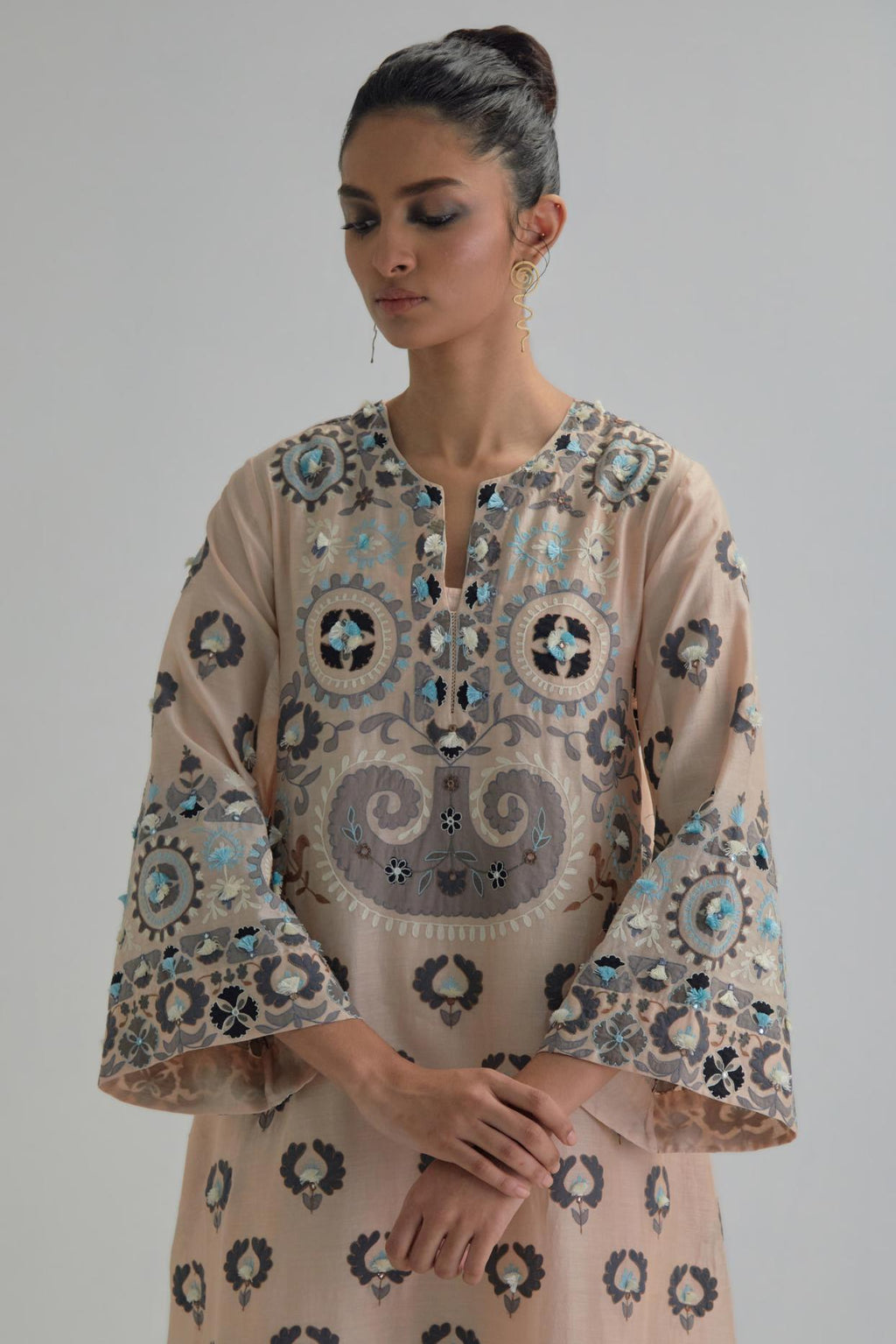 Pink silk Chanderi straight hem mid-length abha style kurta set with bold appliqué embroidery along with earthy-coloured Aari thread work and tassels.