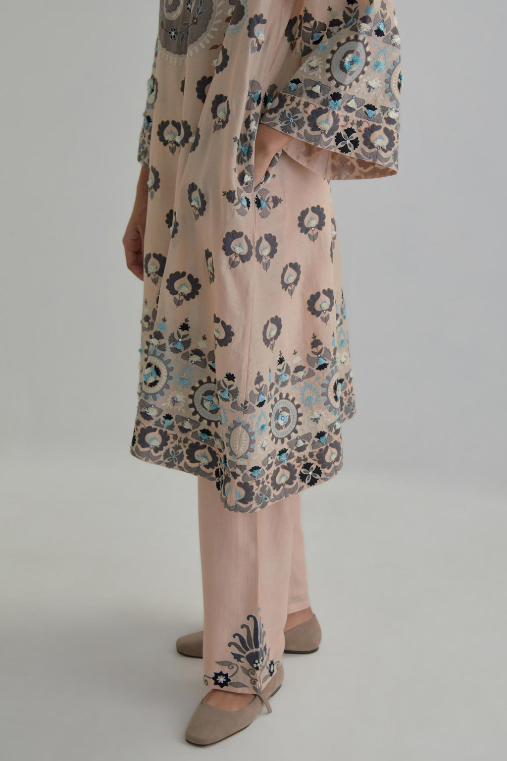 Pink silk Chanderi straight hem mid-length abha style kurta set with bold appliqué embroidery along with earthy-coloured Aari thread work and tassels.