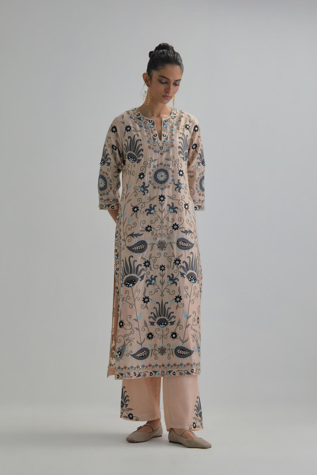 Pink straight kurta set, fully embroidered with bold appliqué flowers, earthy-coloured Aari thread work and silk tassels.