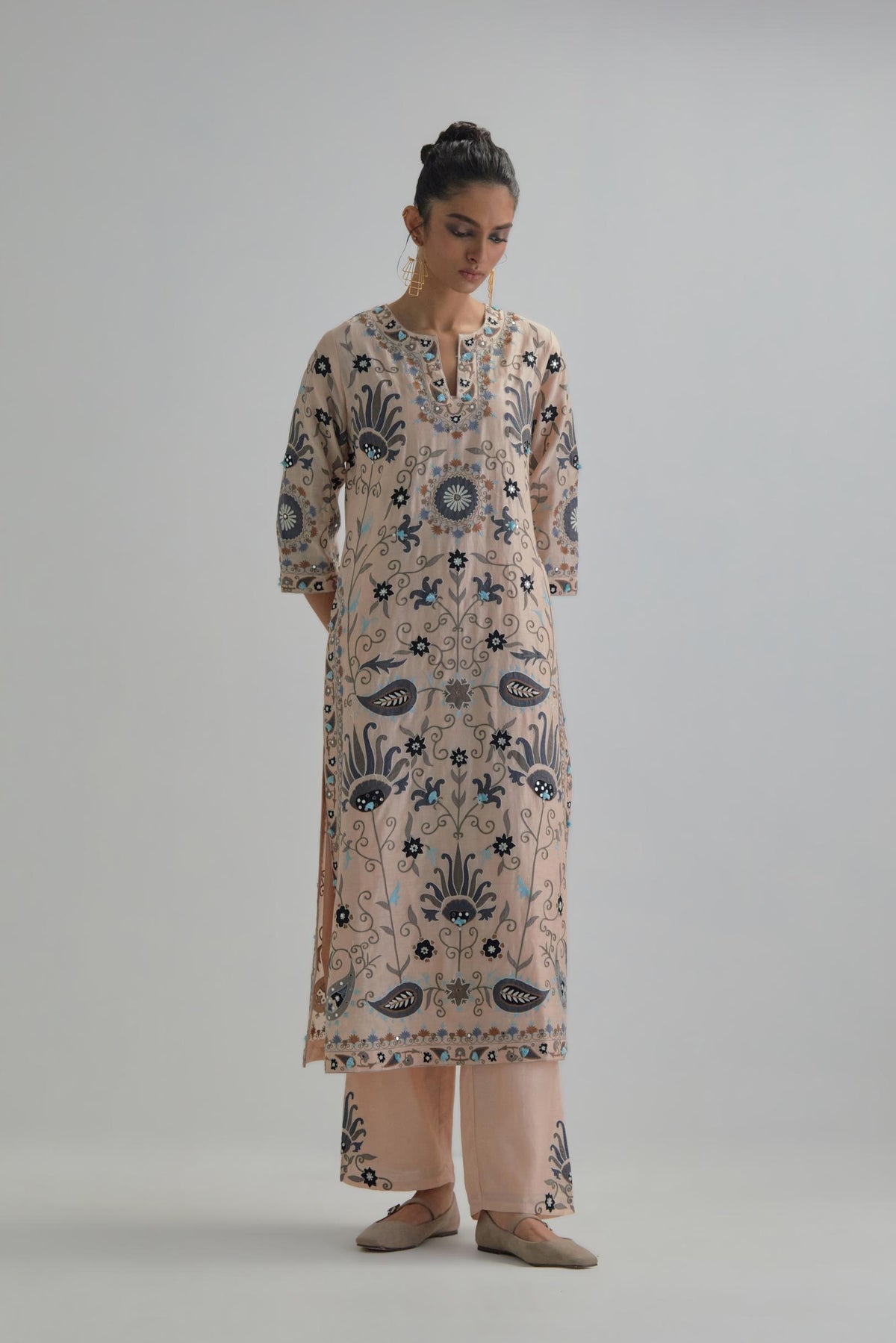 Pink straight kurta set, fully embroidered with bold appliqué flowers, earthy-coloured Aari thread work and silk tassels.