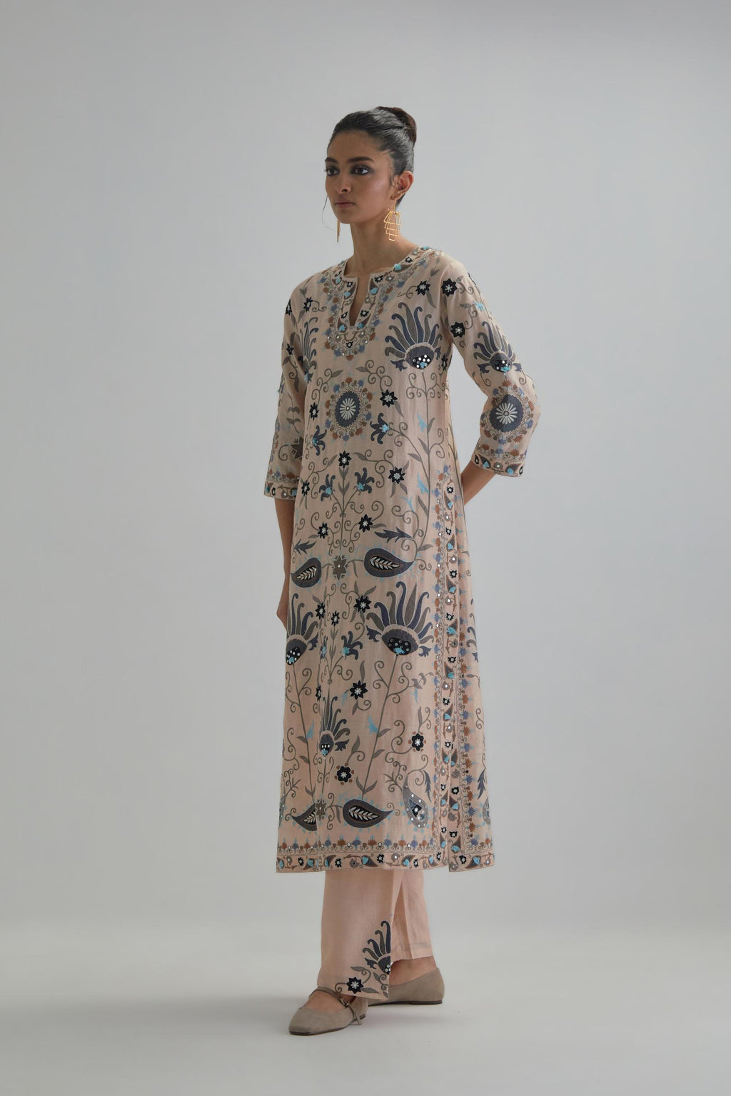 Pink straight kurta set, fully embroidered with bold appliqué flowers, earthy-coloured Aari thread work and silk tassels.