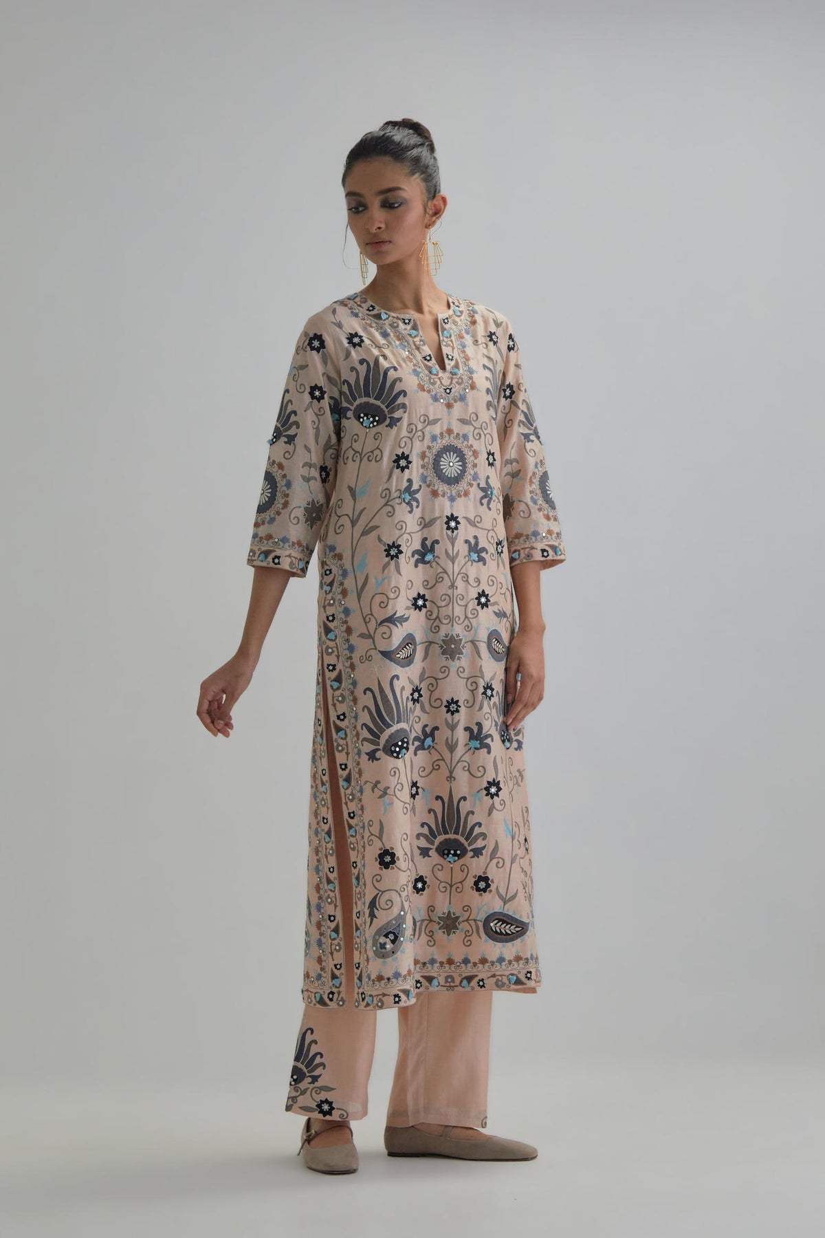 Pink straight kurta set, fully embroidered with bold appliqué flowers, earthy-coloured Aari thread work and silk tassels.