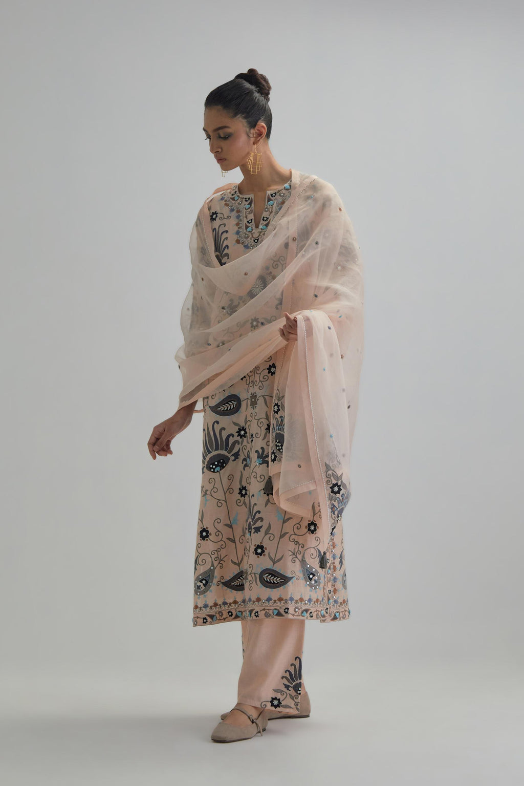 Pink straight kurta set, fully embroidered with bold appliqué flowers, earthy-coloured Aari thread work and silk tassels.
