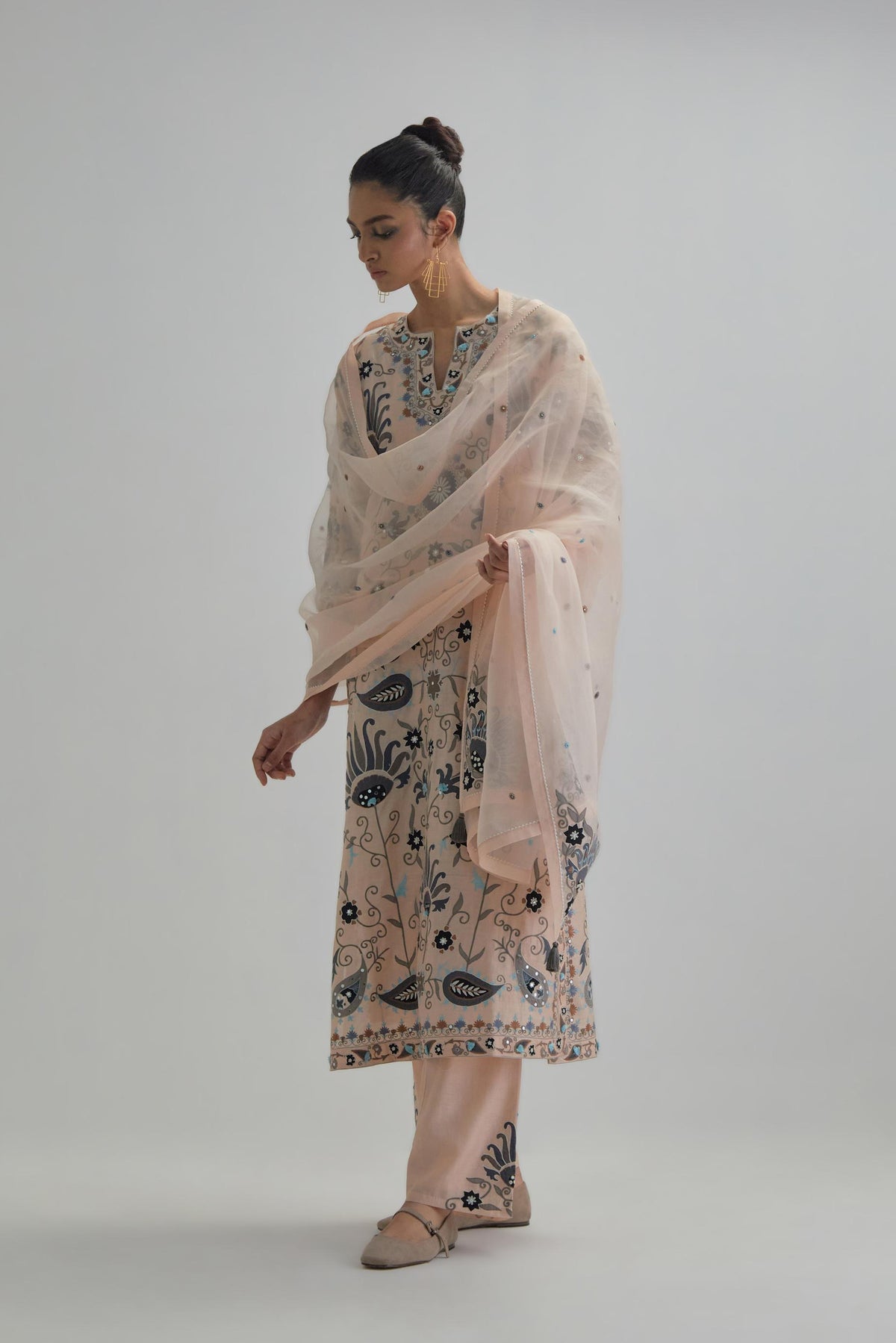 Pink straight kurta set, fully embroidered with bold appliqué flowers, earthy-coloured Aari thread work and silk tassels.