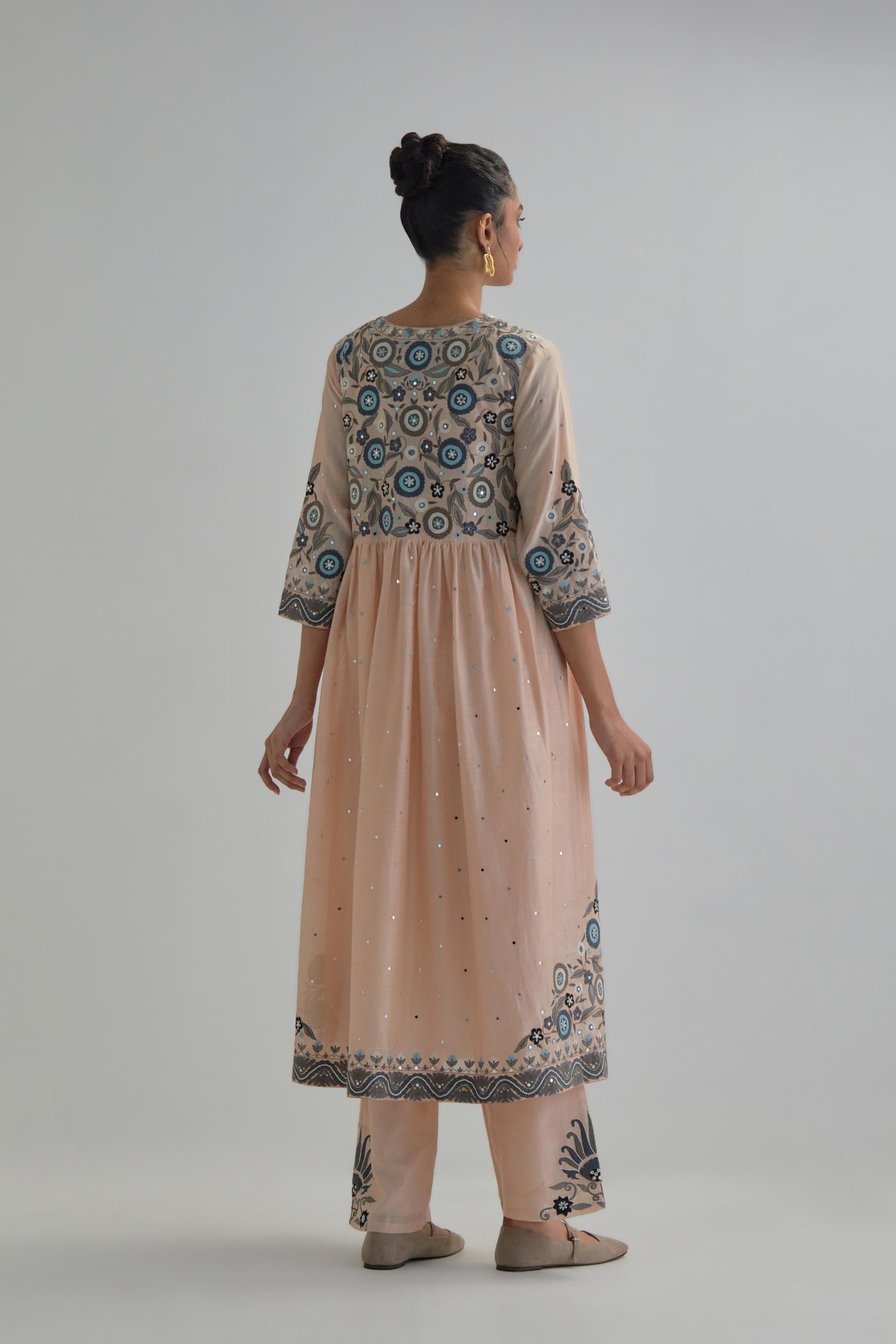 Pink silk Chanderi kurta-dress set with a wavy high-waist and fine gathers. The yoke is fully embroidered with earthy coloured circular appliqué and Aari thread work.