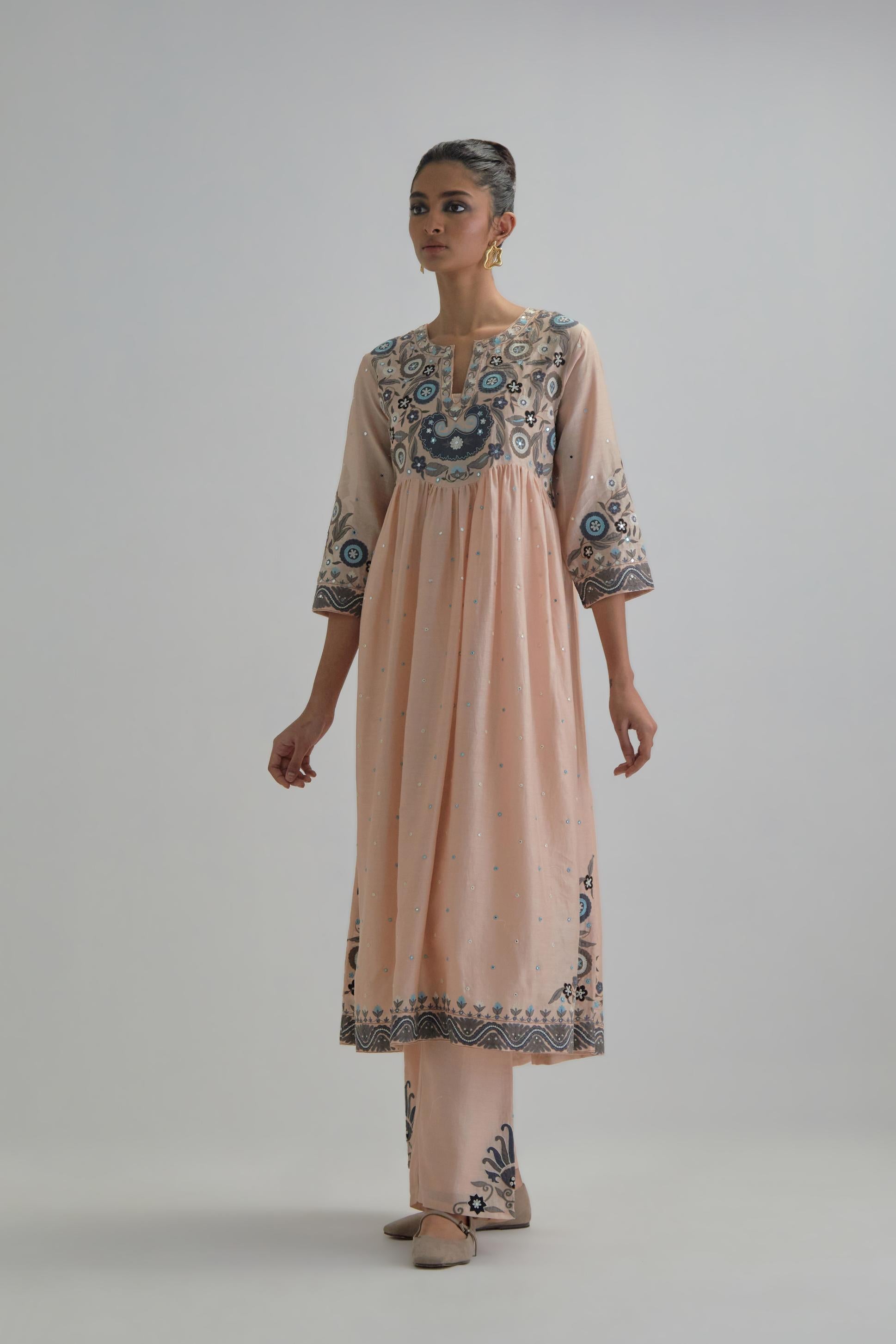 Pink silk Chanderi kurta-dress set with a wavy high-waist and fine gathers. The yoke is fully embroidered with earthy coloured circular appliqué and Aari thread work.