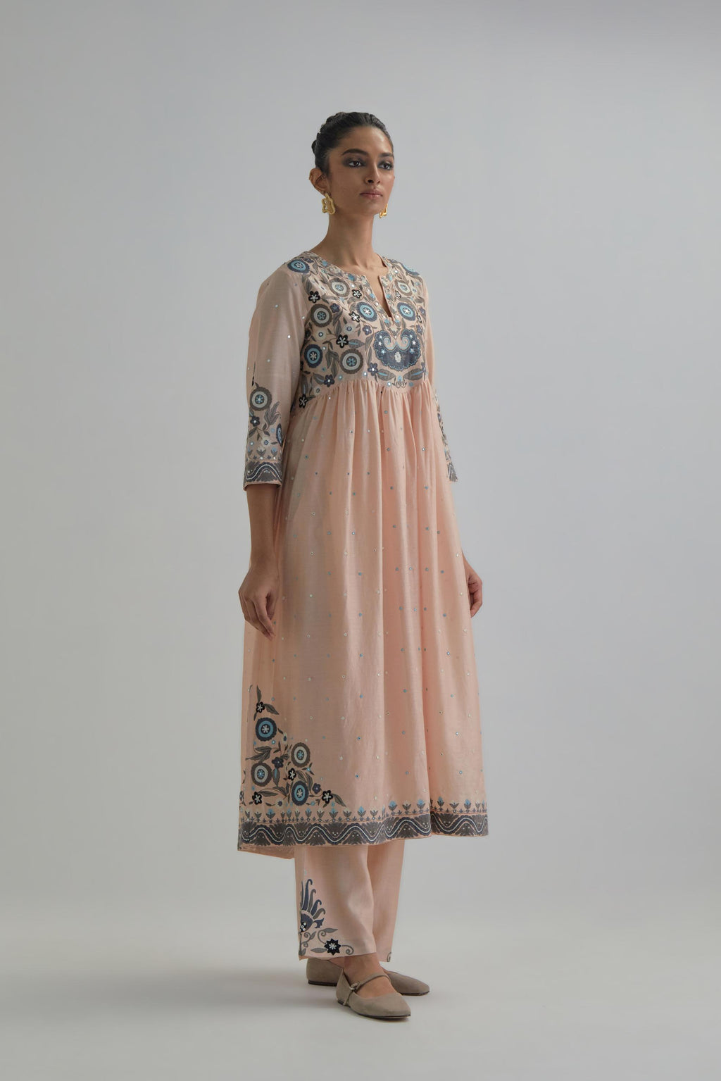 Pink silk Chanderi kurta-dress set with a wavy high-waist and fine gathers. The yoke is fully embroidered with earthy coloured circular appliqué and Aari thread work.