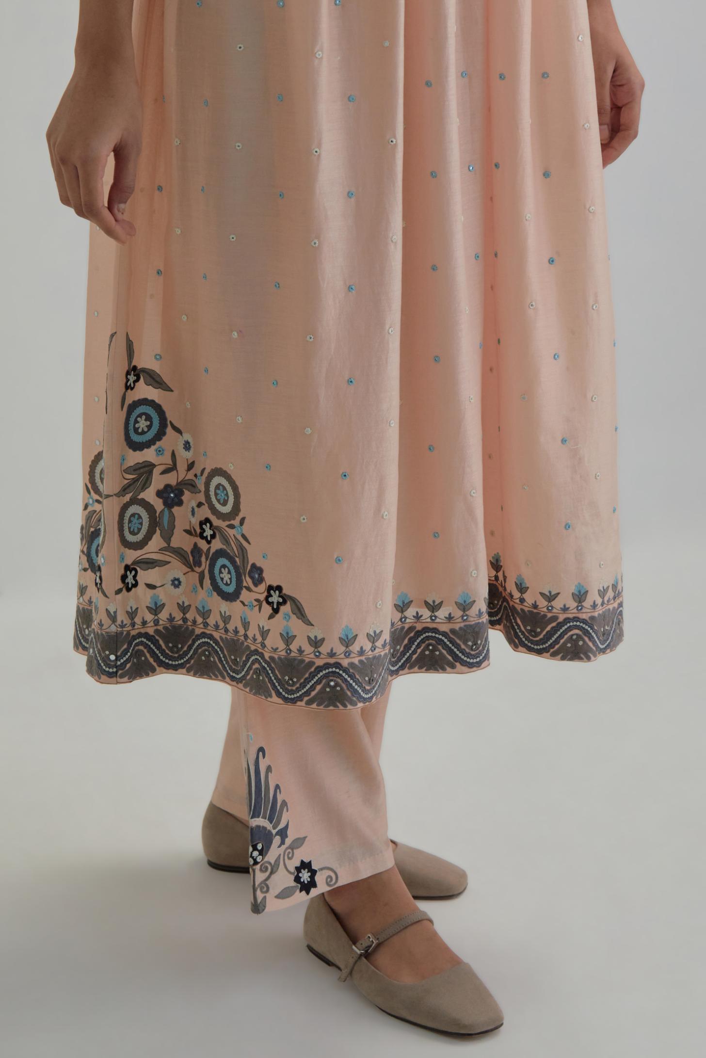 Pink silk Chanderi kurta-dress set with a wavy high-waist and fine gathers. The yoke is fully embroidered with earthy coloured circular appliqué and Aari thread work.