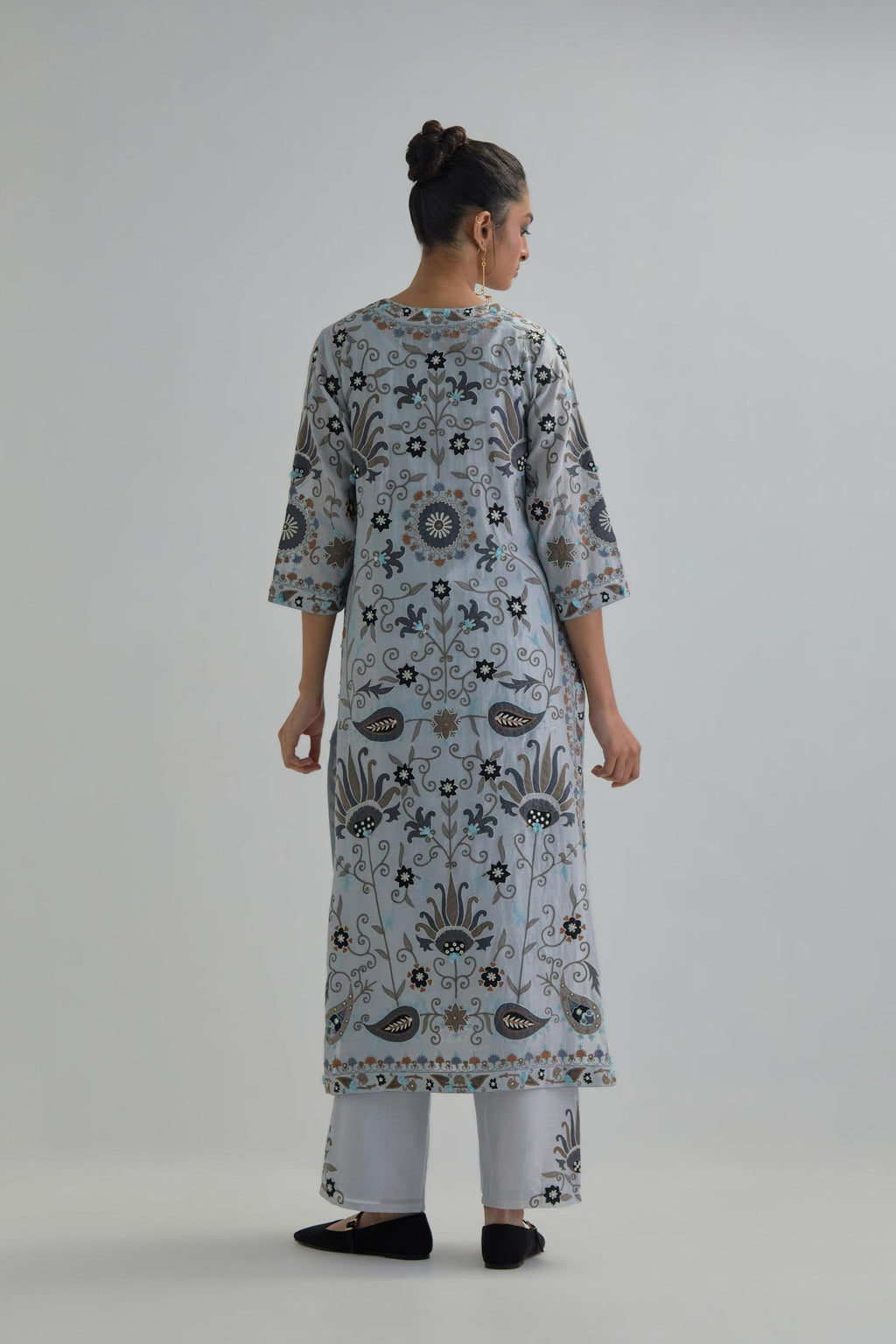 Blue straight kurta set, fully embroidered with bold appliqué flowers, earthy-coloured Aari thread work and silk tassels.
