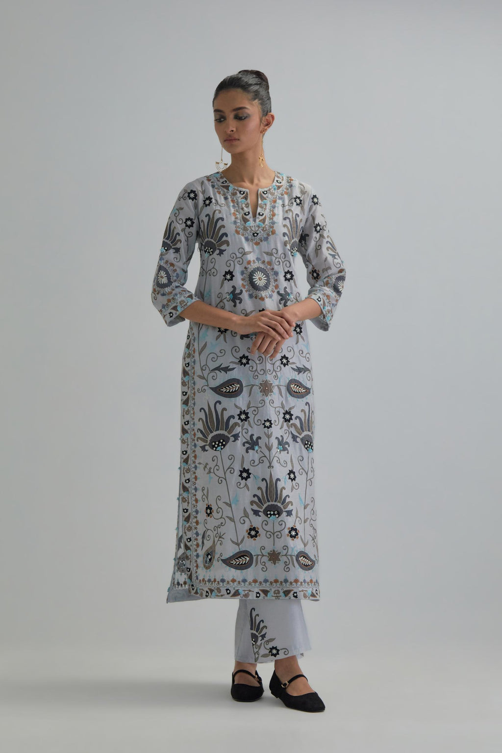 Blue straight kurta set, fully embroidered with bold appliqué flowers, earthy-coloured Aari thread work and silk tassels.