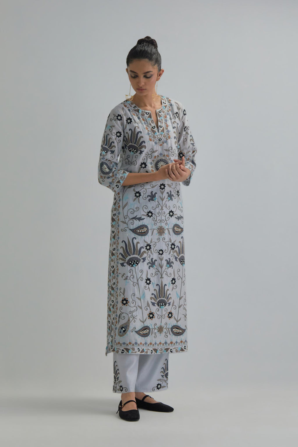 Blue straight kurta set, fully embroidered with bold appliqué flowers, earthy-coloured Aari thread work and silk tassels.