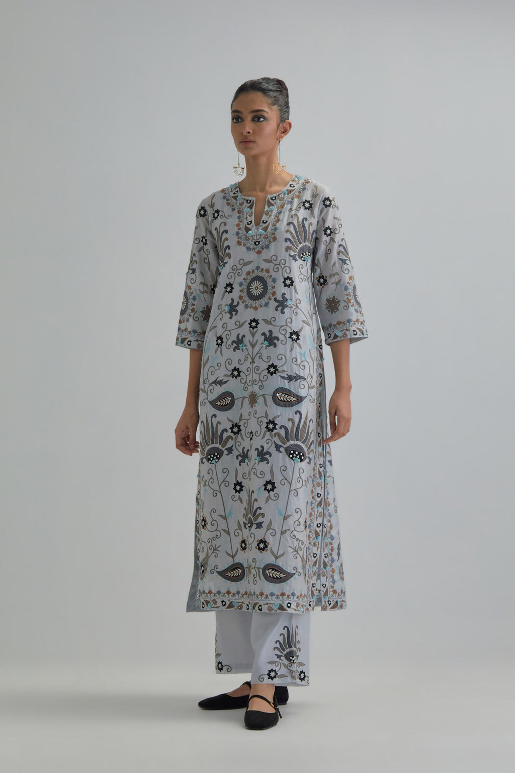 Blue straight kurta set, fully embroidered with bold appliqué flowers, earthy-coloured Aari thread work and silk tassels.