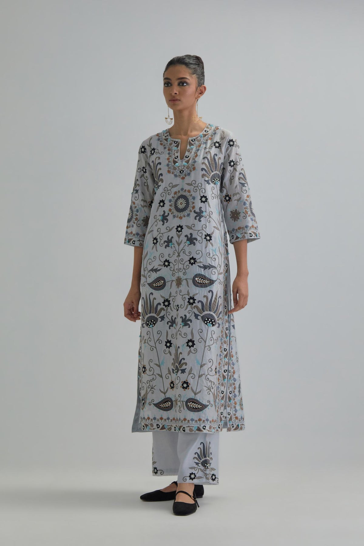 Blue straight kurta set, fully embroidered with bold appliqué flowers, earthy-coloured Aari thread work and silk tassels.