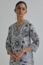Blue straight kurta set, fully embroidered with bold appliqué flowers, earthy-coloured Aari thread work and silk tassels.