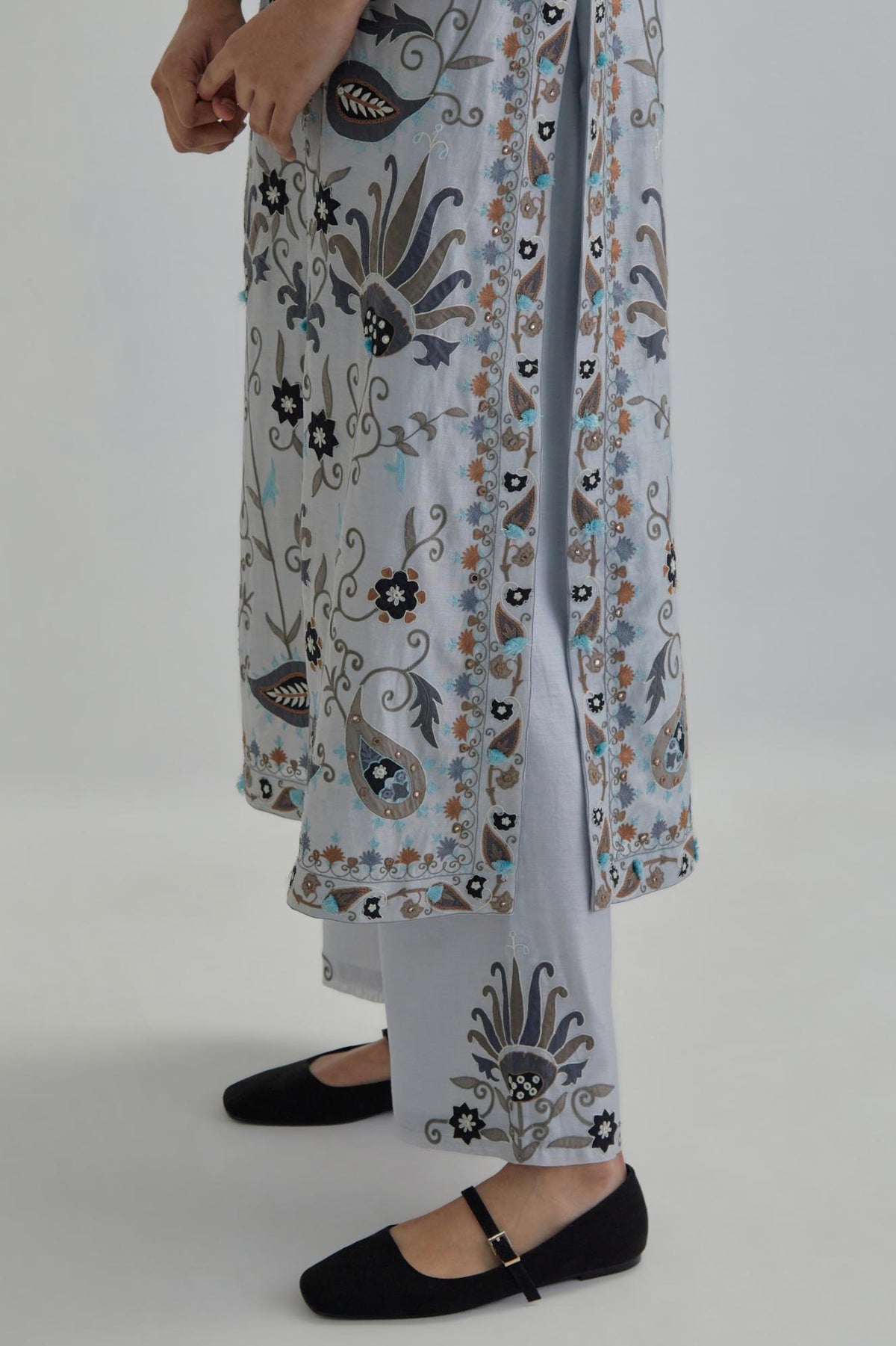 Blue straight kurta set, fully embroidered with bold appliqué flowers, earthy-coloured Aari thread work and silk tassels.