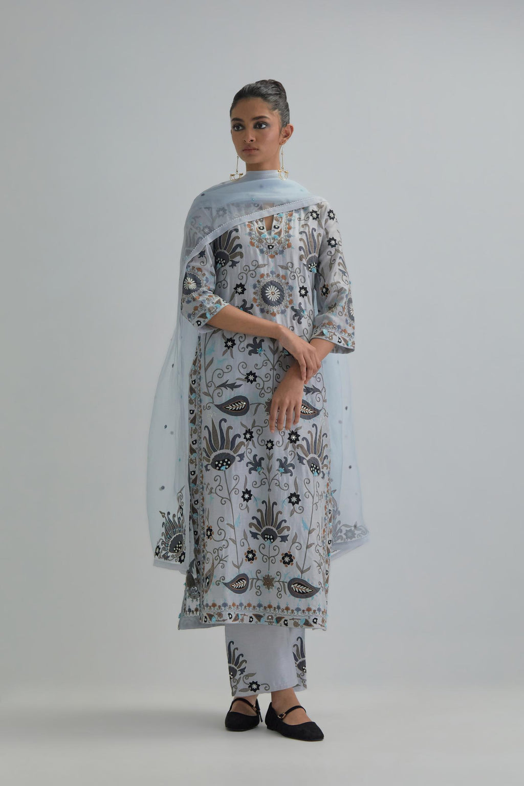 Blue straight kurta set, fully embroidered with bold appliqué flowers, earthy-coloured Aari thread work and silk tassels.