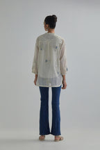 Off white cotton Chanderi top with all-over delicate embroidered blue & beige hand block printed applique flowers, highlighted with sequins and multi coloured beads.