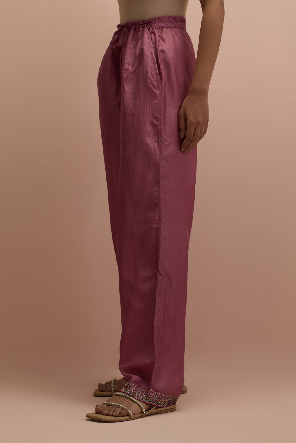 Salmon pink silk straight pants with sequins and multi-colored beadwork at hem.