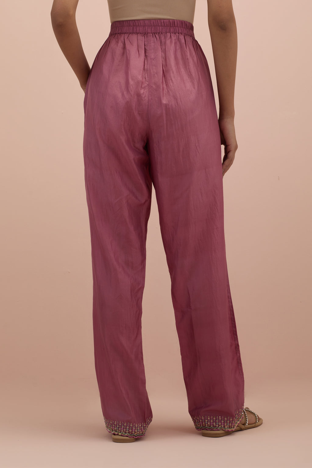 Salmon pink silk straight pants with sequins and multi-colored beadwork at hem.