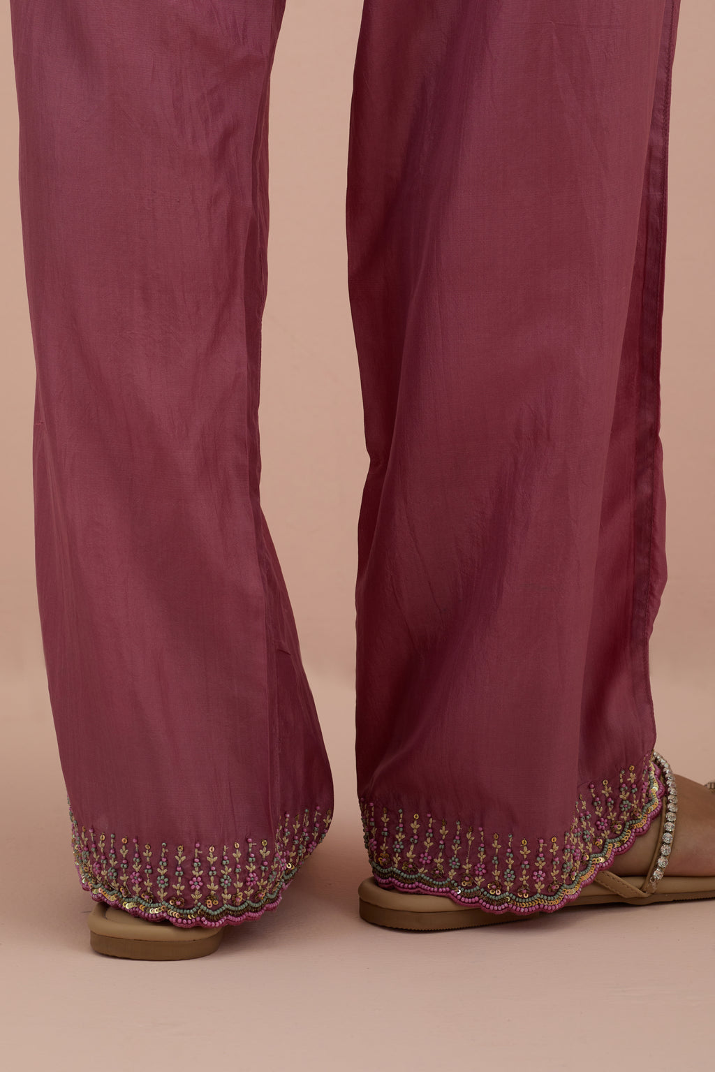 Salmon pink silk straight pants with sequins and multi-colored beadwork at hem.