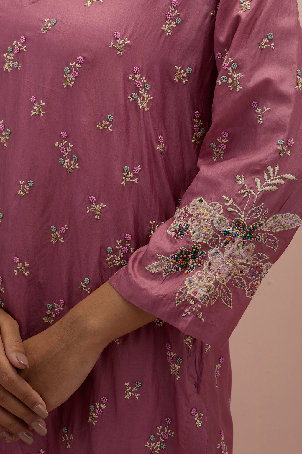 Salmon pink silk straight kurta set with all-over delicate embroidered flowers, highlighted with sequins and multi-colored beads.