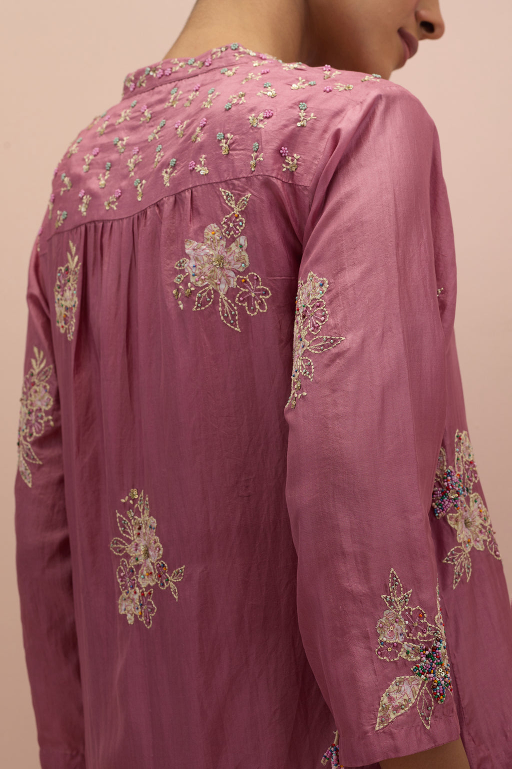 Salmon pink straight kurta set with all-over delicate embroidered flowers, highlighted with sequins and multi-colored beads.