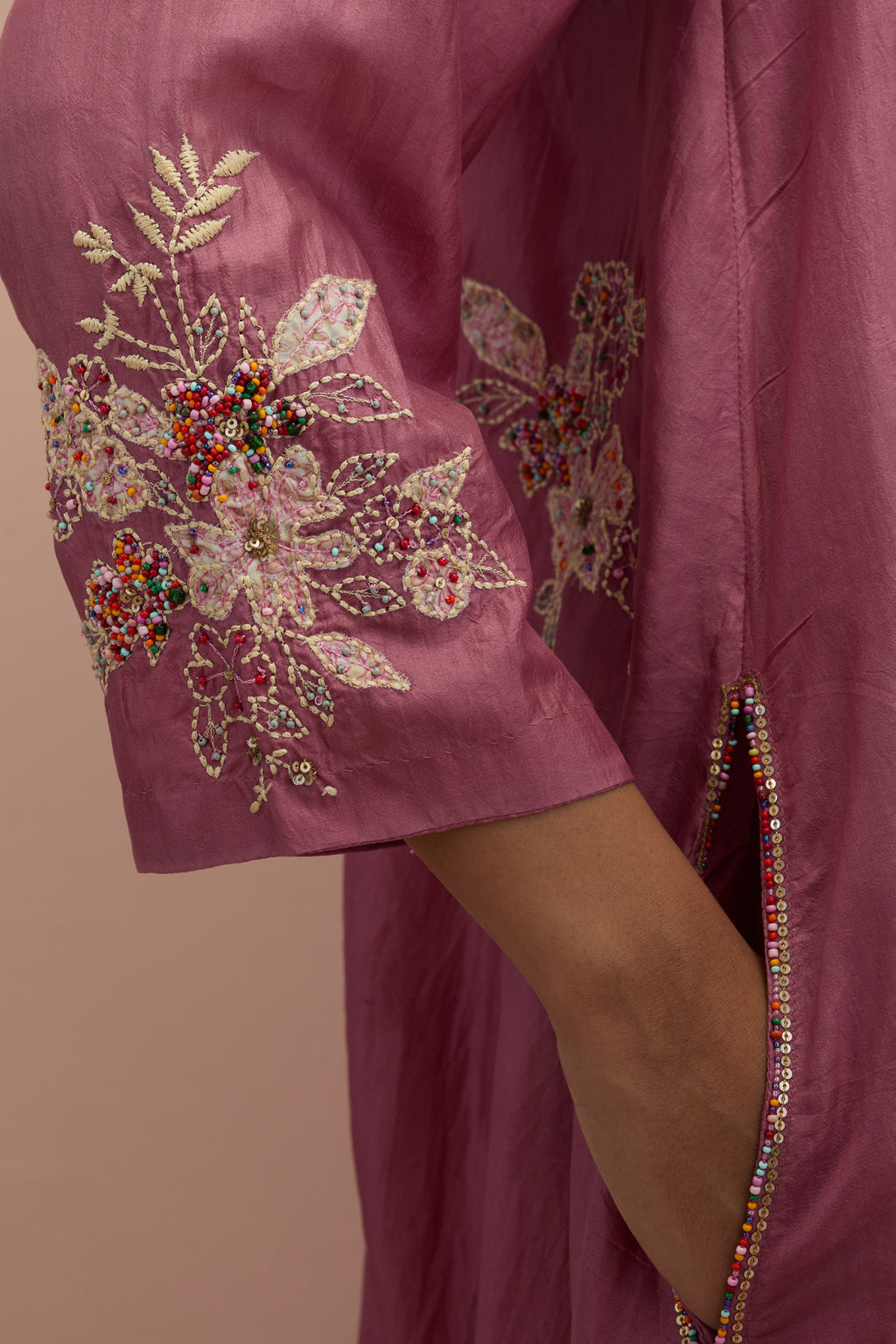 Salmon pink silk short shirt-kurta set with all-over appliqué flowers, highlighted with sequins and multi-colored beads.