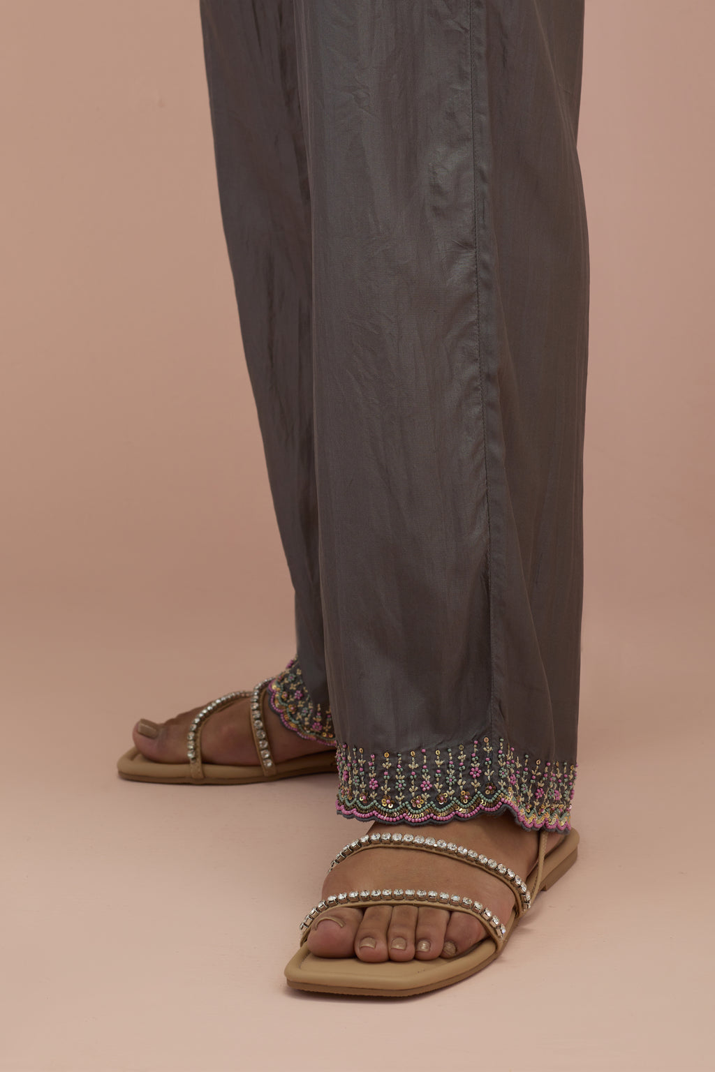 Iron grey silk straight pants with sequins and multi-colored beadwork at hem.