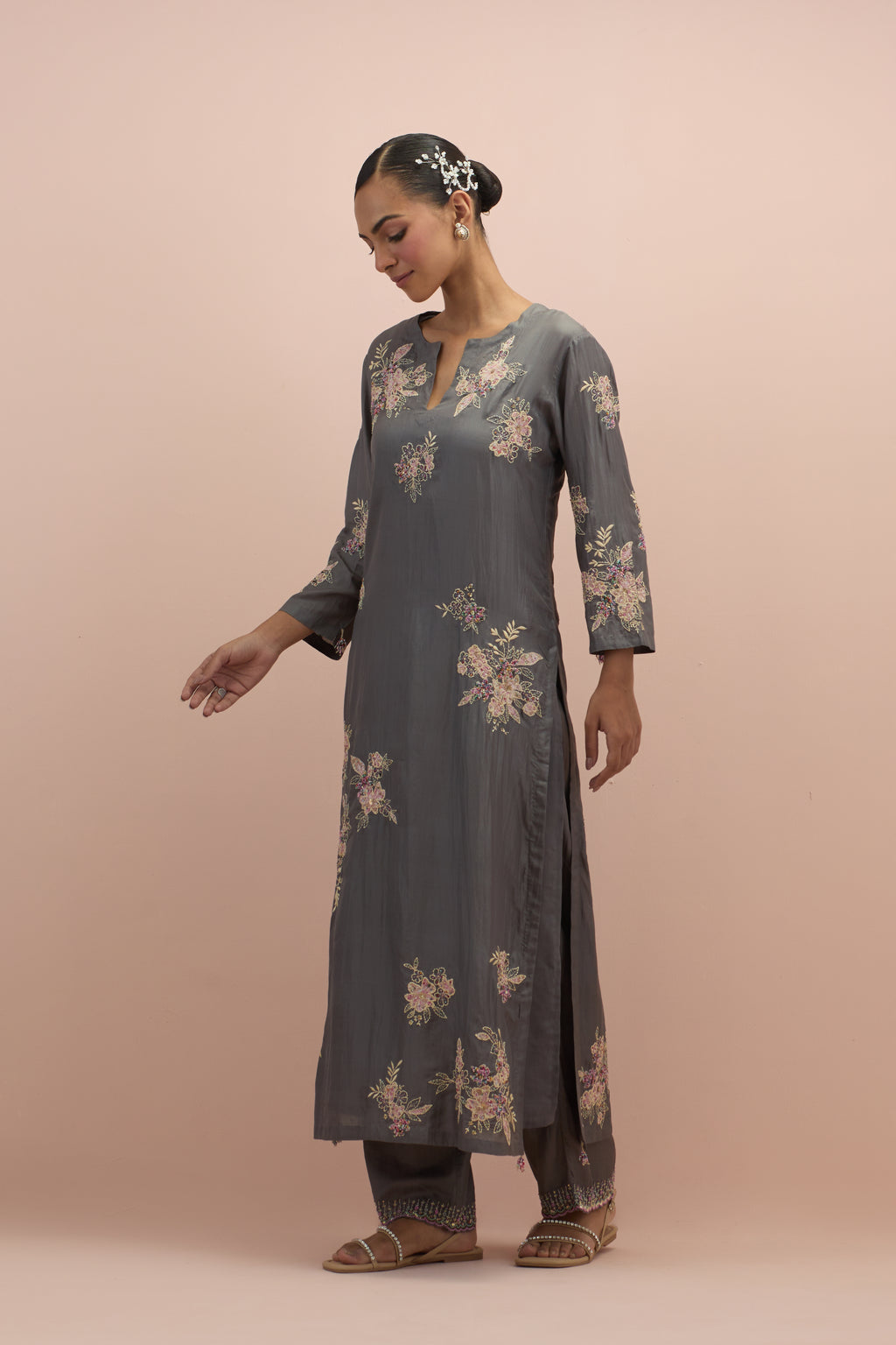 Iron grey silk straight kurta set with randomly placed hand block printed appliquéd flowers, highlighted with sequins and multi-colored beads.