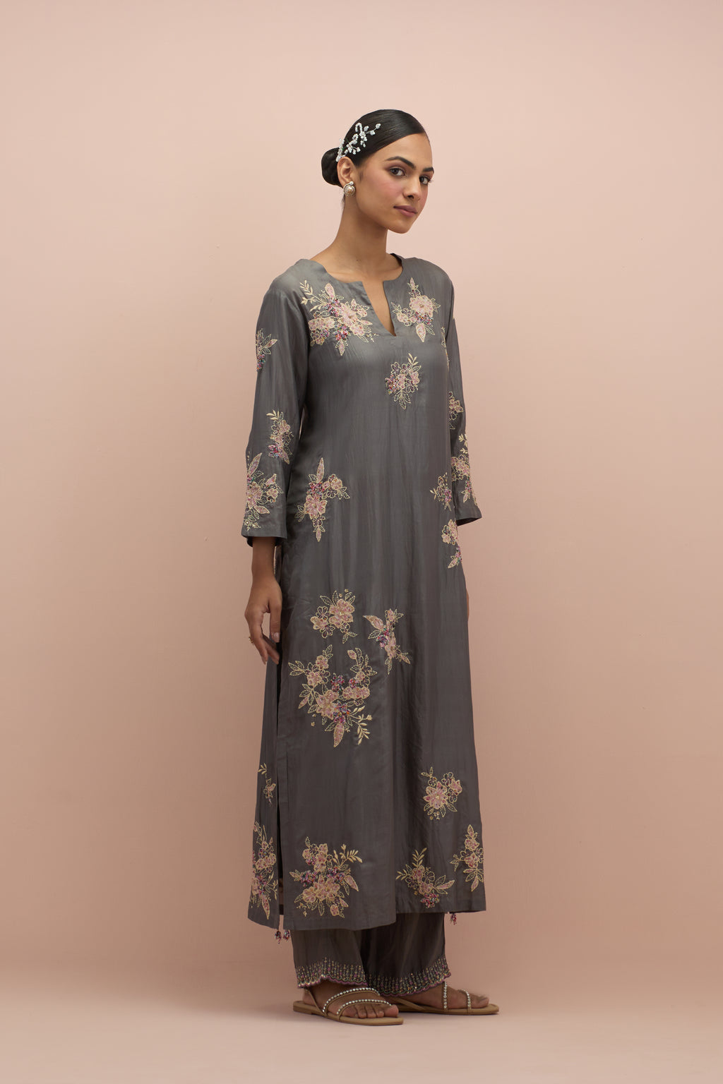 Iron grey silk straight kurta set with randomly placed hand block printed appliquéd flowers, highlighted with sequins and multi-colored beads.