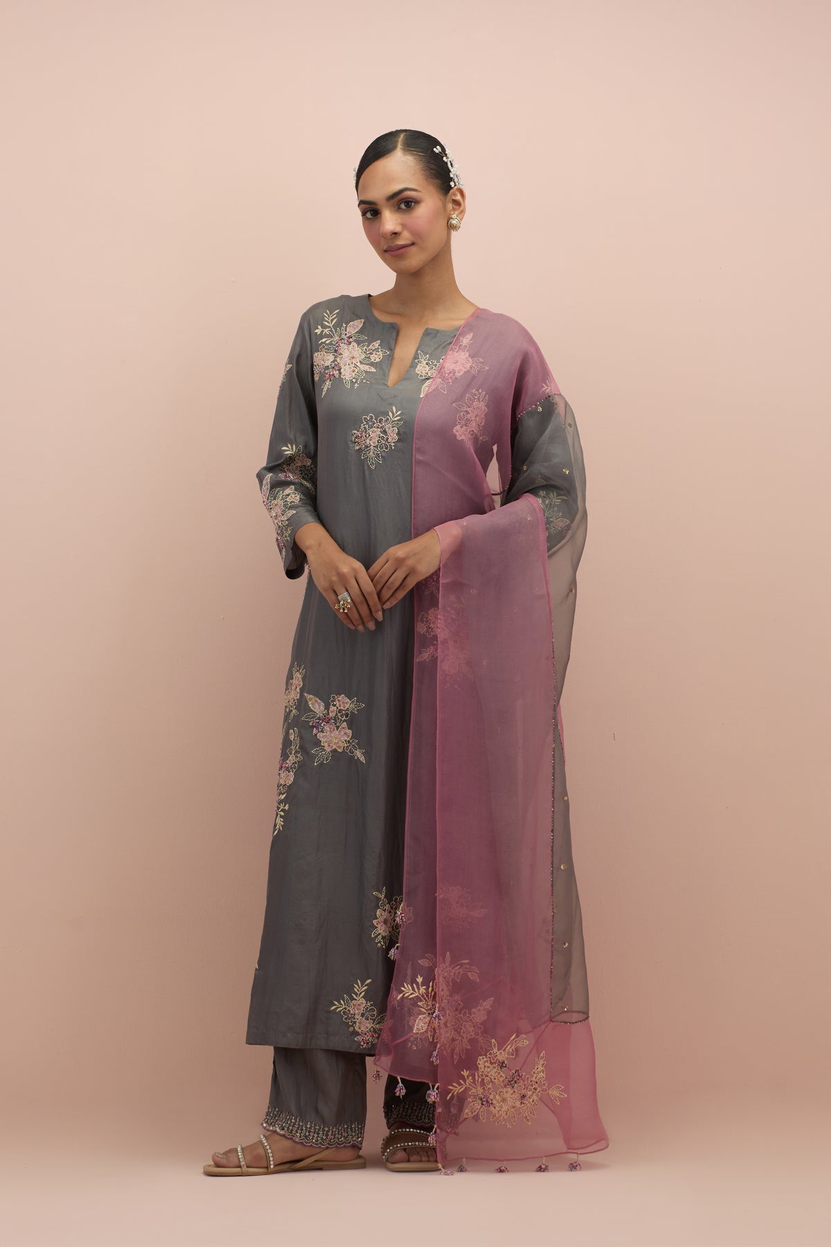 Iron grey silk straight kurta set with randomly placed hand block printed appliquéd flowers, highlighted with sequins and multi-colored beads.