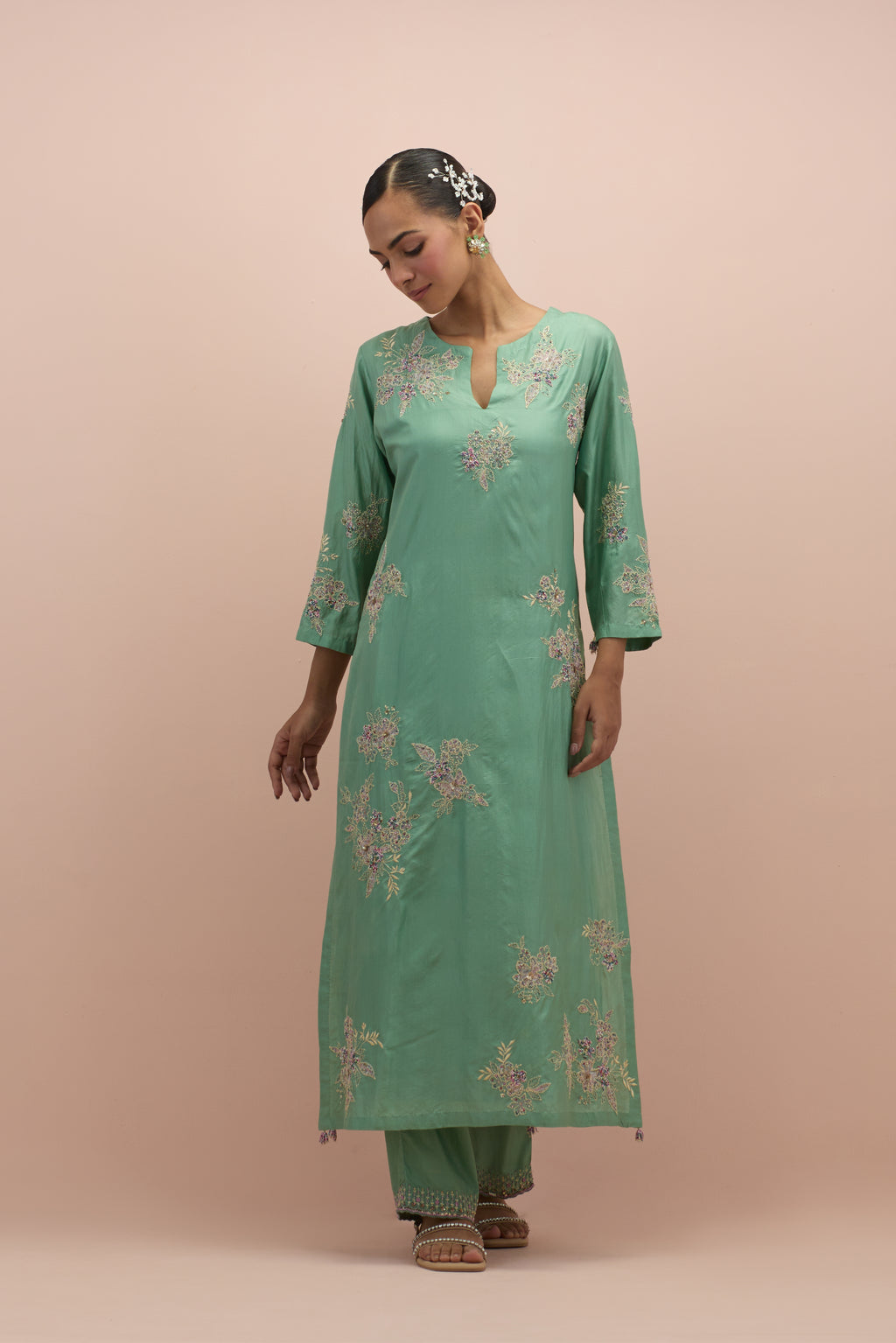 jade green silk straight kurta set with randomly placed hand block printed appliquéd flowers, highlighted with sequins and multi-colored beads.