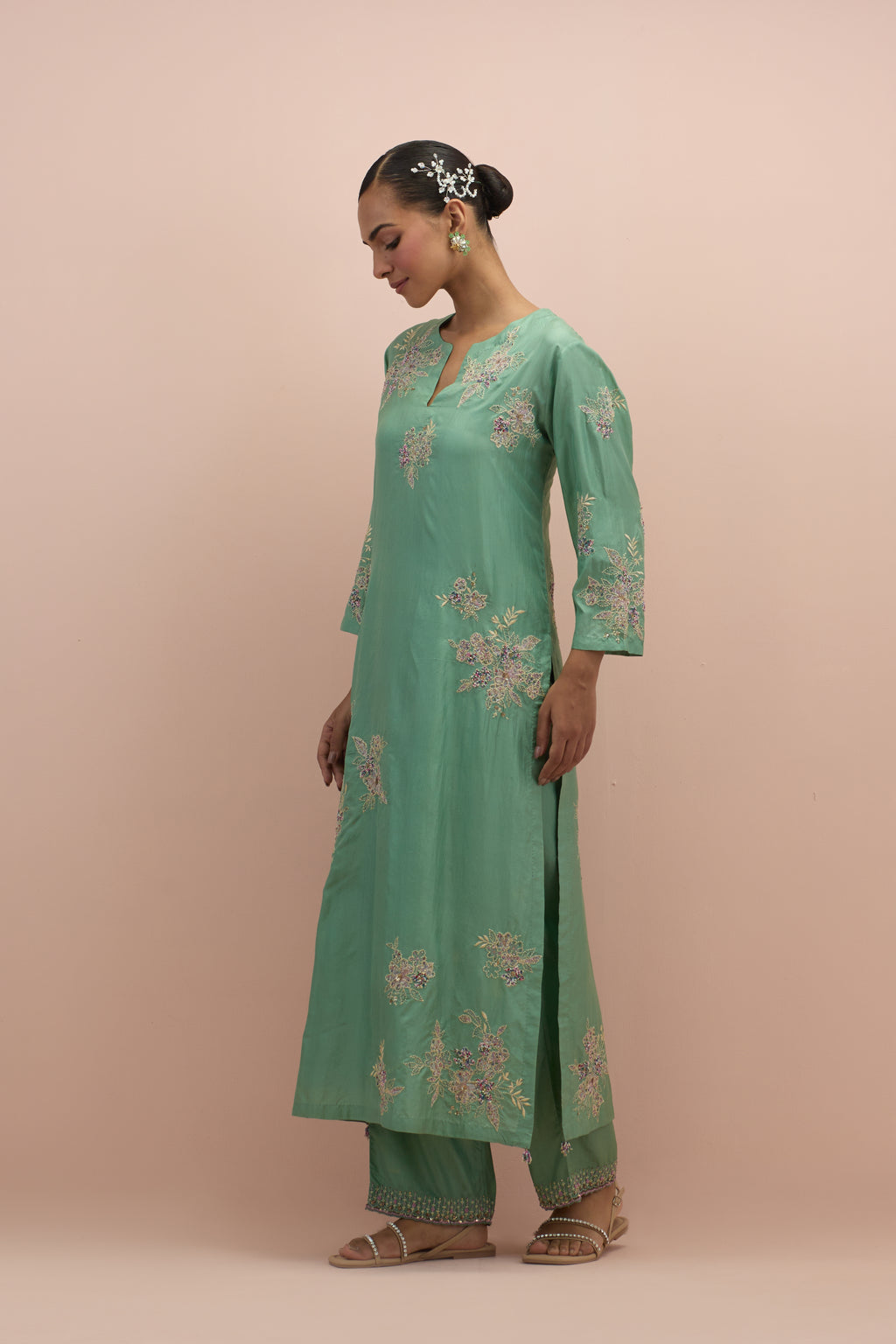 jade green silk straight kurta set with randomly placed hand block printed appliquéd flowers, highlighted with sequins and multi-colored beads.