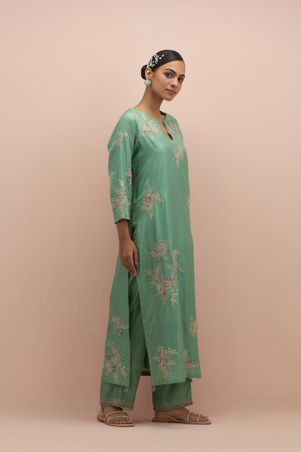 jade green silk straight kurta set with randomly placed hand block printed appliquéd flowers, highlighted with sequins and multi-colored beads.