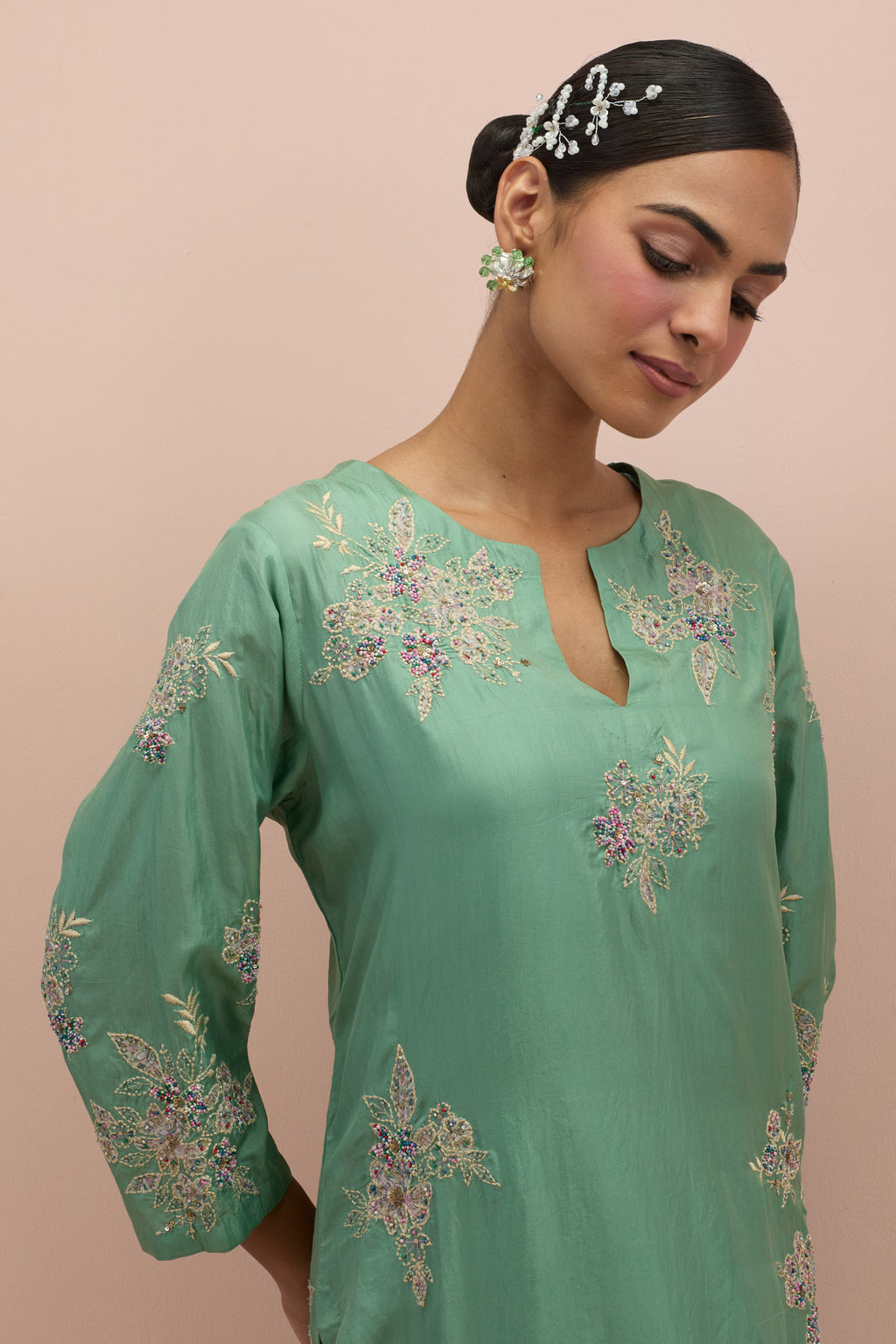 jade green silk straight kurta set with randomly placed hand block printed appliquéd flowers, highlighted with sequins and multi-colored beads.