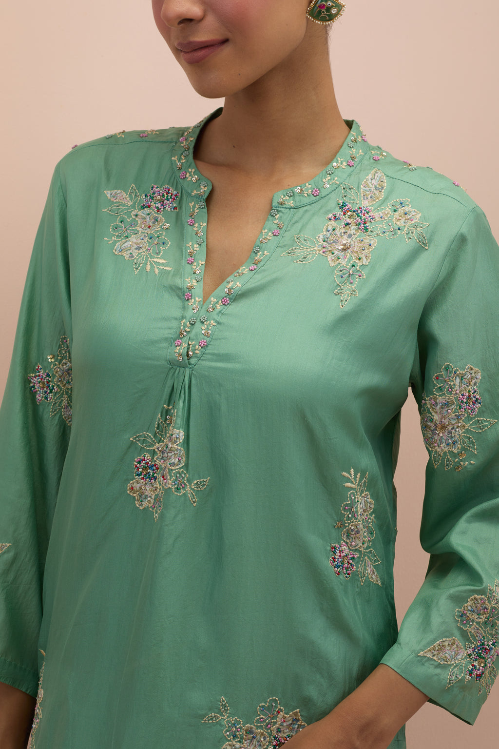 Jade green straight kurta set with all-over delicate embroidered flowers, highlighted with sequins and multi-colored beads.