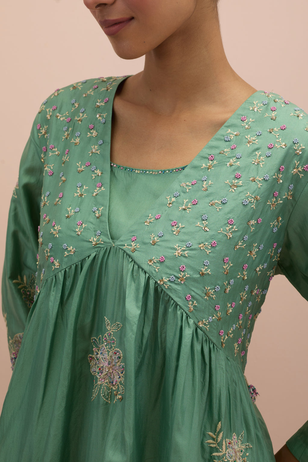 Jade green silk kurta dress set with delicate embroidered flowers and hand block printed appliqué motifs, highlighted with sequins and multi-colored beads.