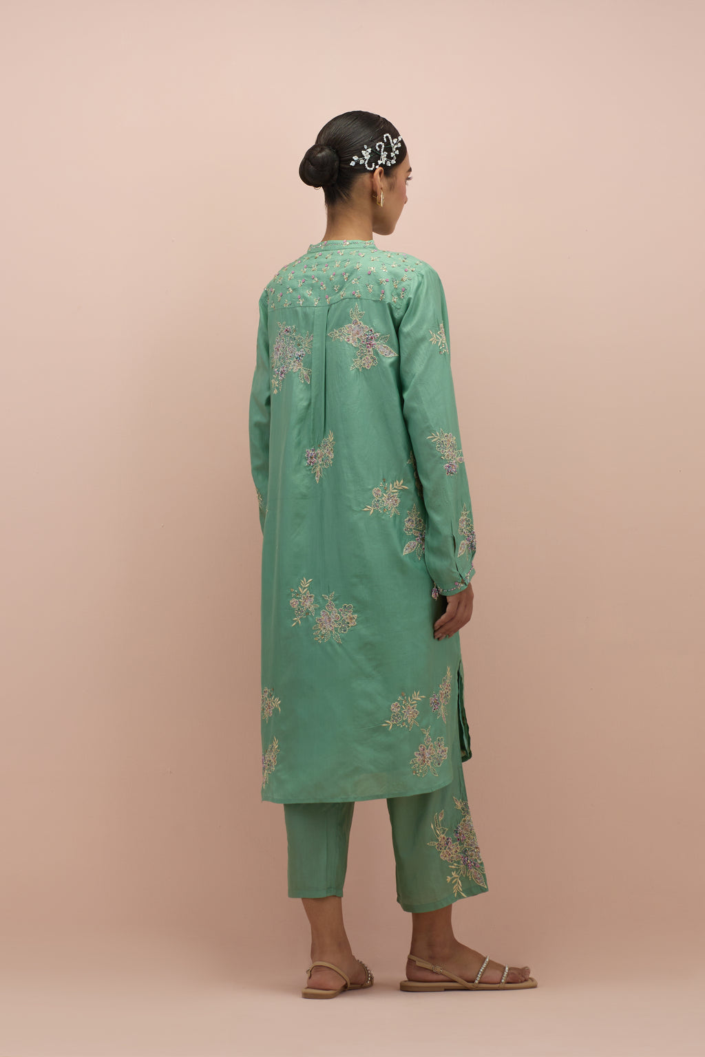 Jade green silk short shirt kurta with all-over hand block printed appliqué, highlighted with sequins and multi colored beads, paired with jade green silk ankle length straight pants with hand block printed appliqué motifs at the sides.