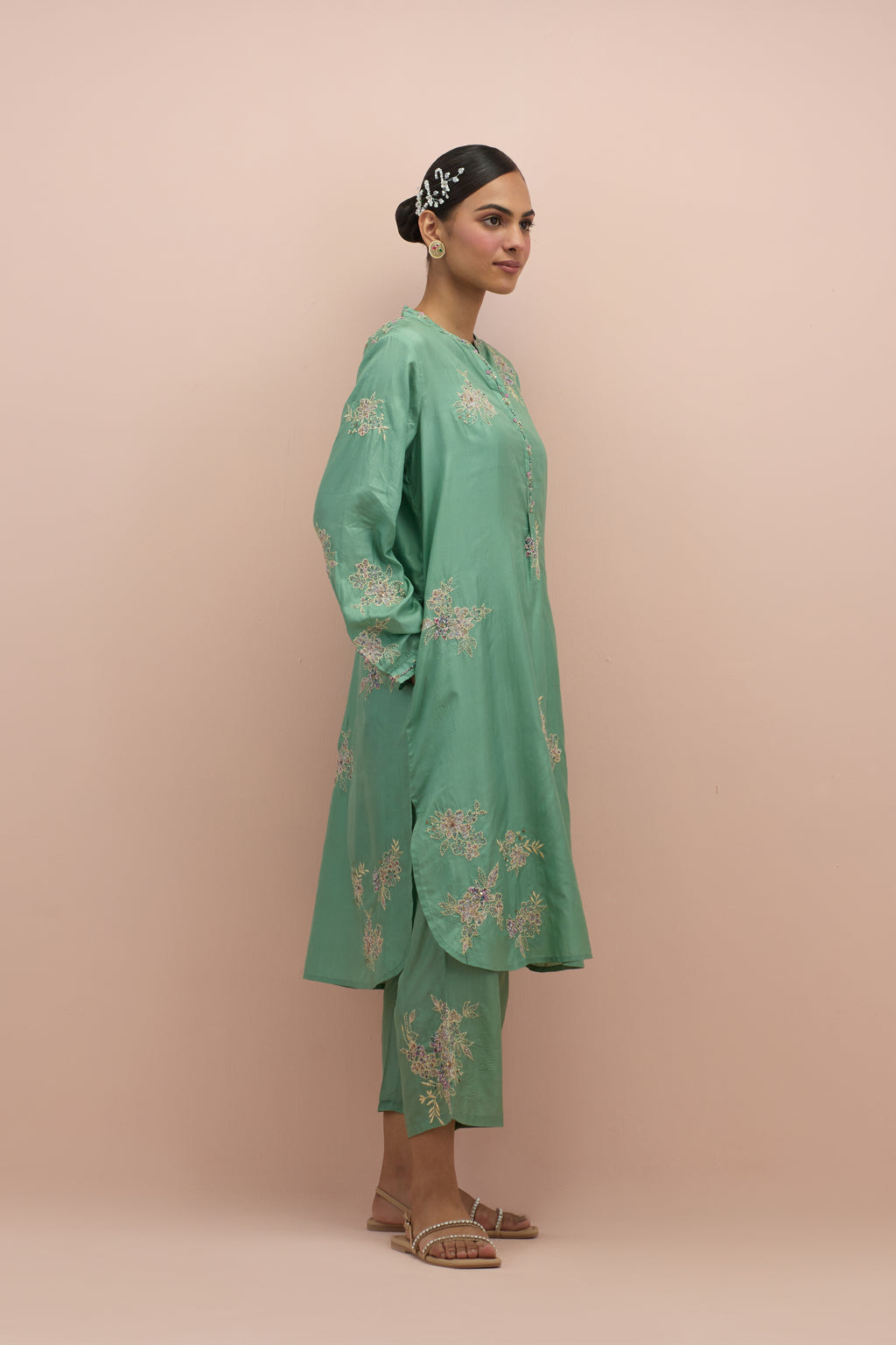 Jade green silk short shirt kurta with all-over hand block printed appliqué, highlighted with sequins and multi colored beads, paired with jade green silk ankle length straight pants with hand block printed appliqué motifs at the sides.