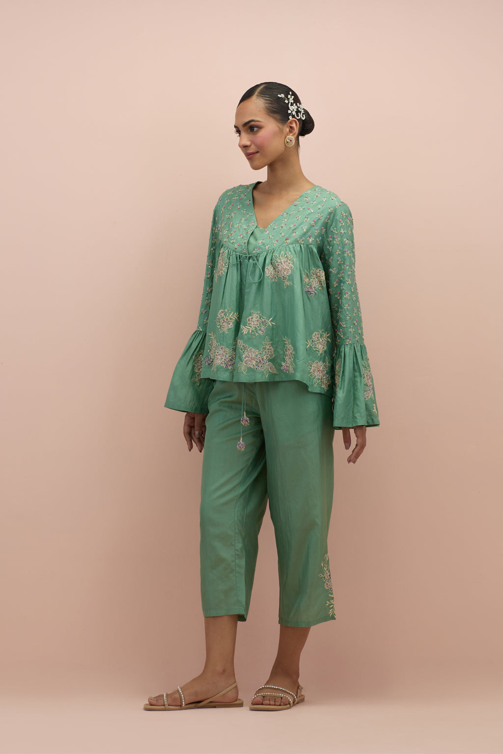 Jade green silk short top with hand block printed appliqué motifs and delicate embroidered flowers, highlighted with sequins and multi-colored beads, paired with jade green silk ankle length straight pants.