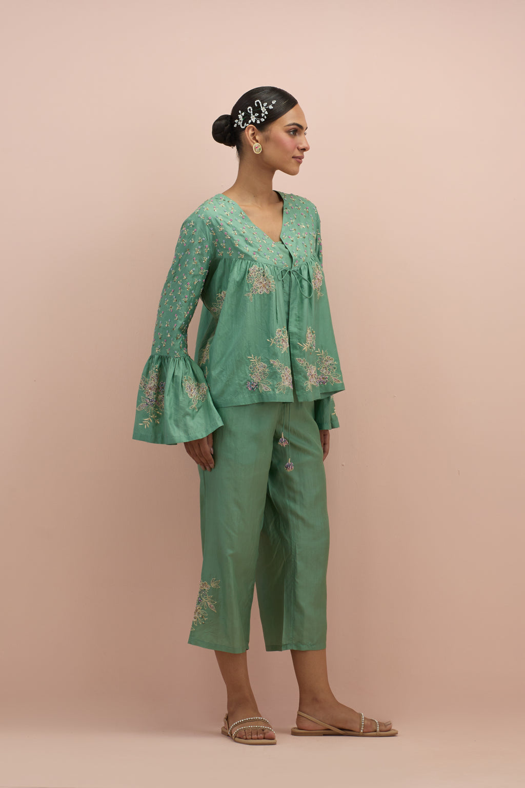 Jade green silk short top with hand block printed appliqué motifs and delicate embroidered flowers, highlighted with sequins and multi-colored beads, paired with jade green silk ankle length straight pants.