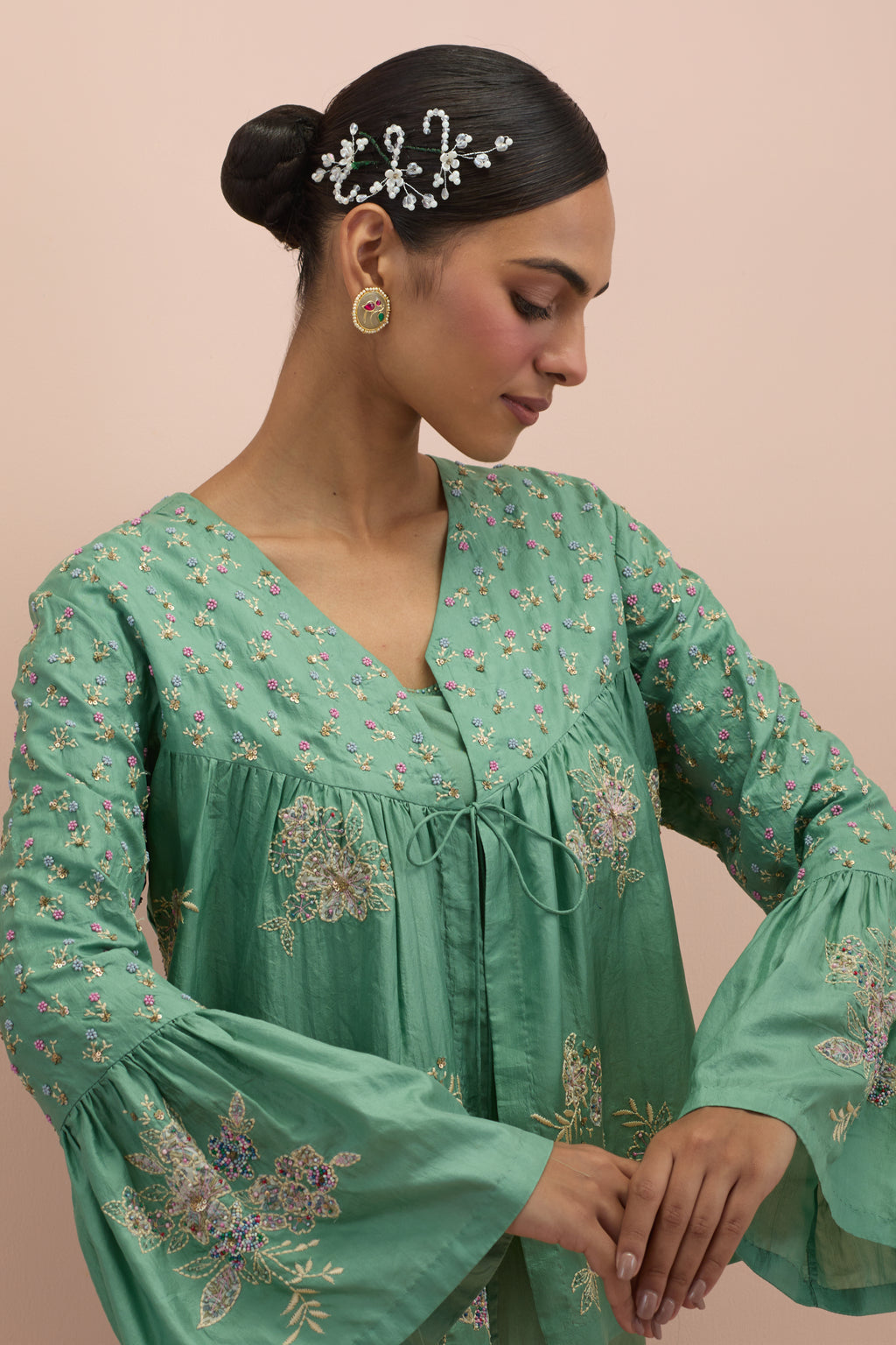 Jade green silk short top with hand block printed appliqué motifs and delicate embroidered flowers, highlighted with sequins and multi-colored beads, paired with jade green silk ankle length straight pants.