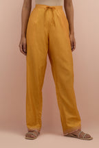 Amber silk straight pants with sequins and multi-colored beadwork at hem.